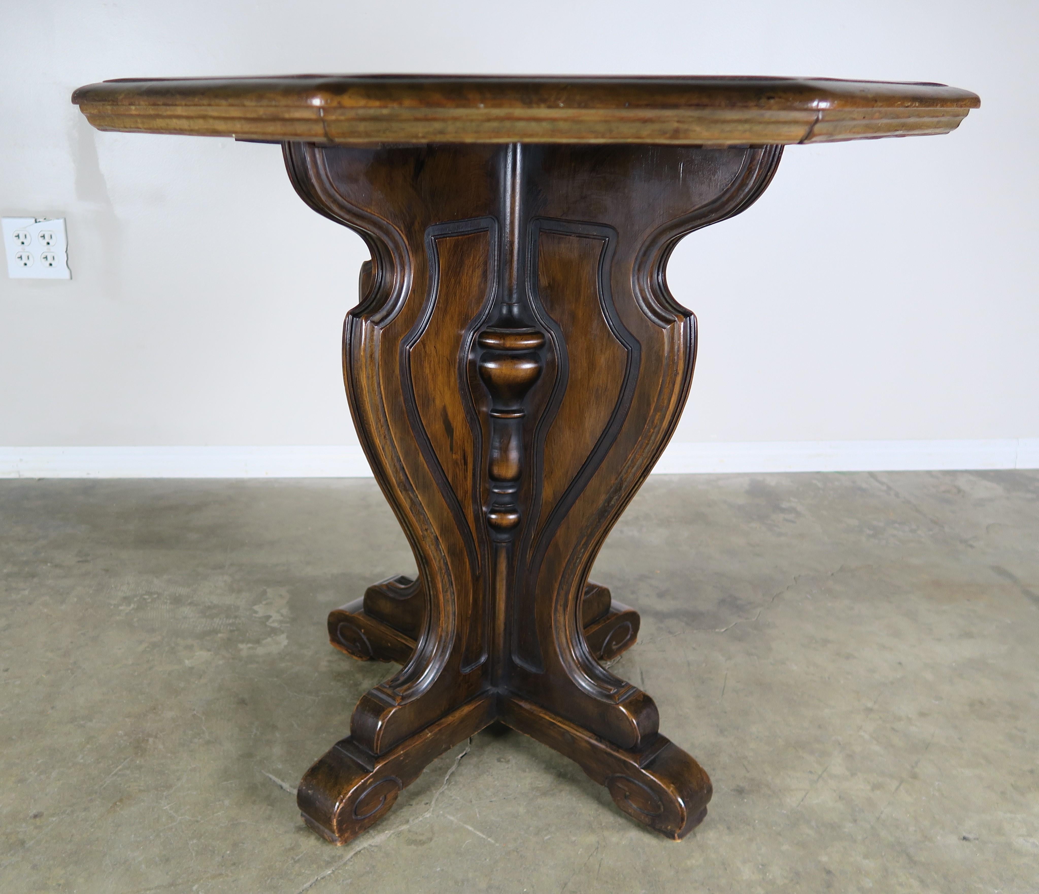 Italian walnut octagonal shaped table standing on a pedestal base that stands on four feet.
 