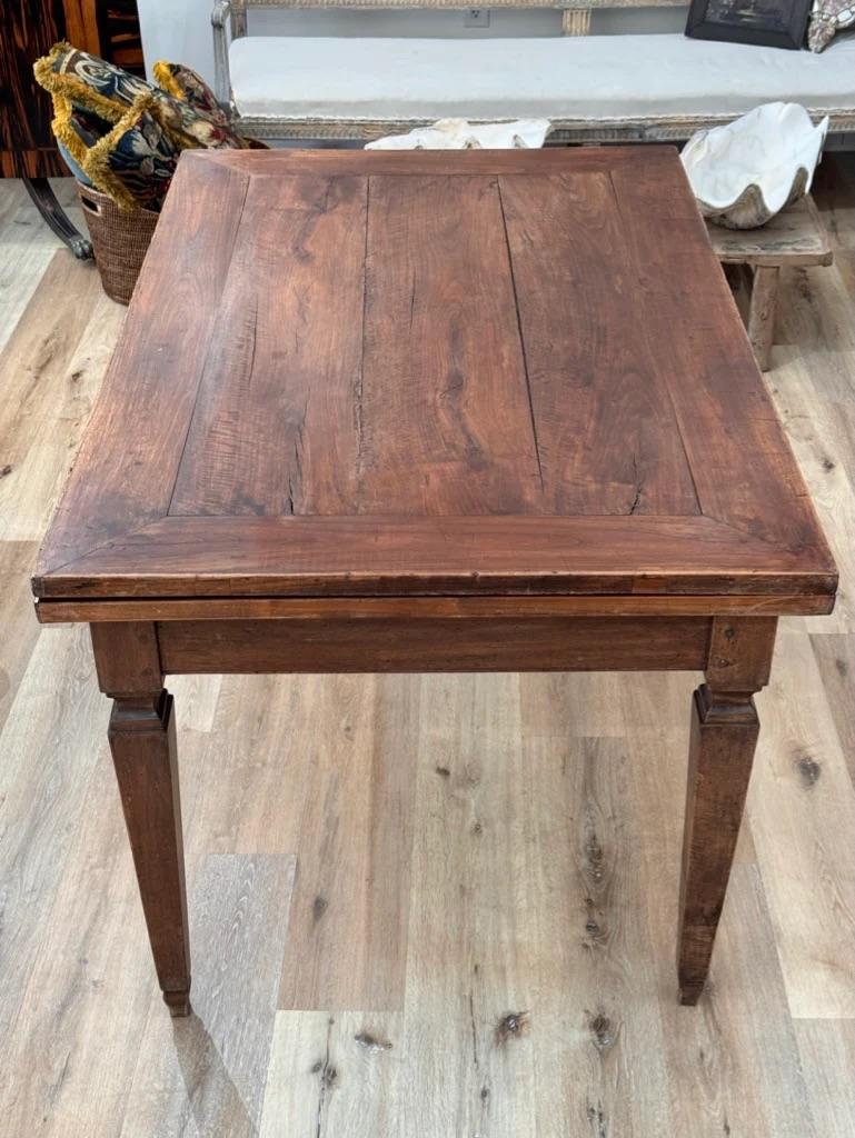Italian folding rectangular dining table, walnut, 19th Century, possibly earlier, having an excellent patina.  Having a very heavy folding top that, when closed rotates over the open base (great for storage) and folds over to make a table half its