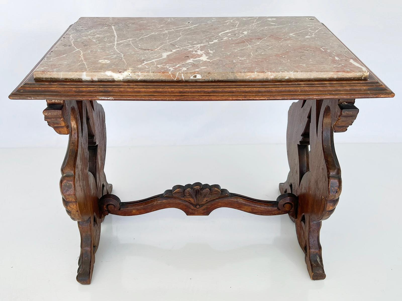 An Italian Renaissance style side table, of carved walnut, having a rectangular marble top, in molded frame, raised on legs hand-carved as griffins, joined by a scrolling H-stretcher. 

Stock ID: D3667