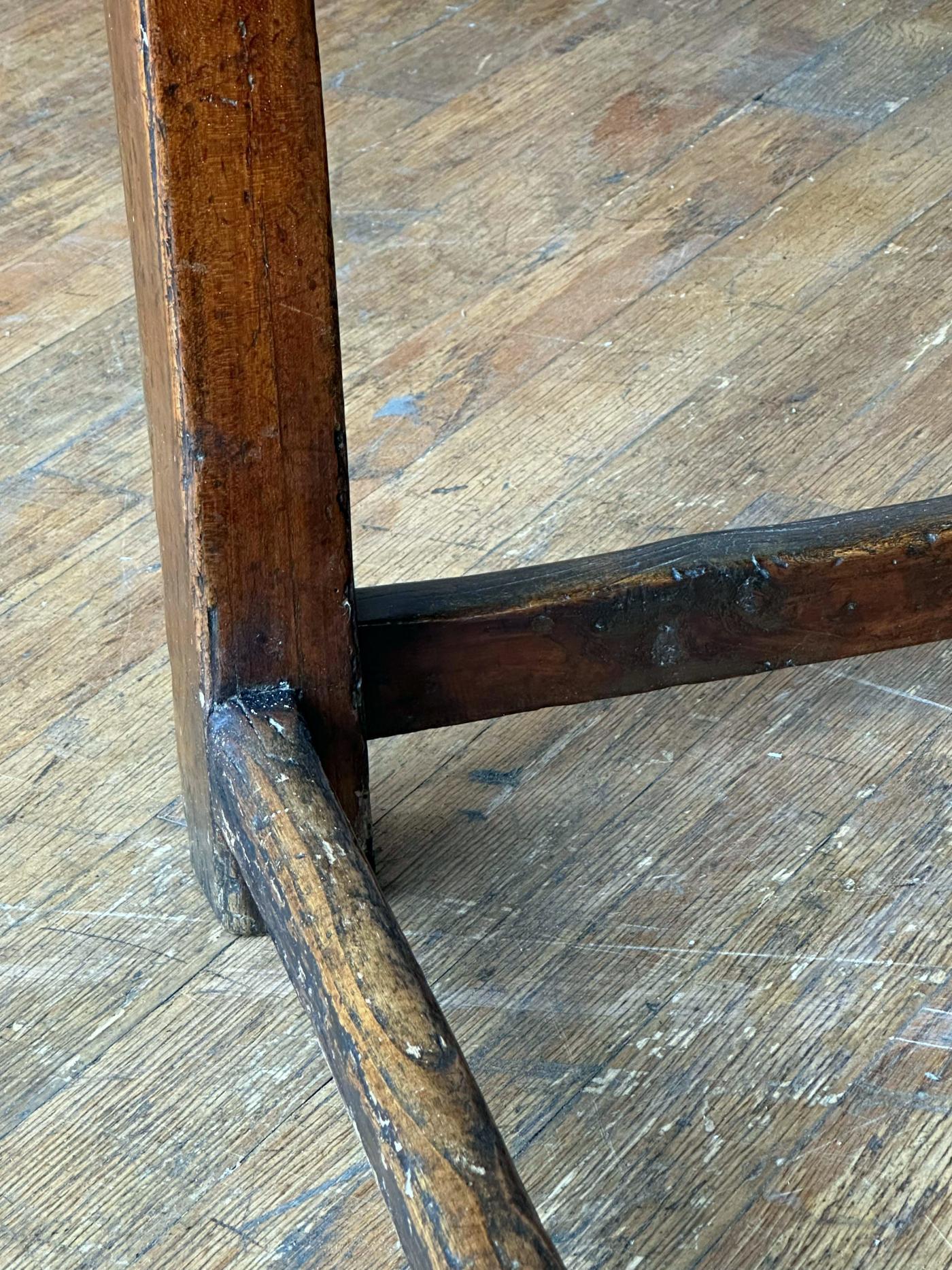 Die rechteckige Platte über einer langen Schublade steht auf abgeschrägten Beinen, die mit Streckern verbunden sind. 