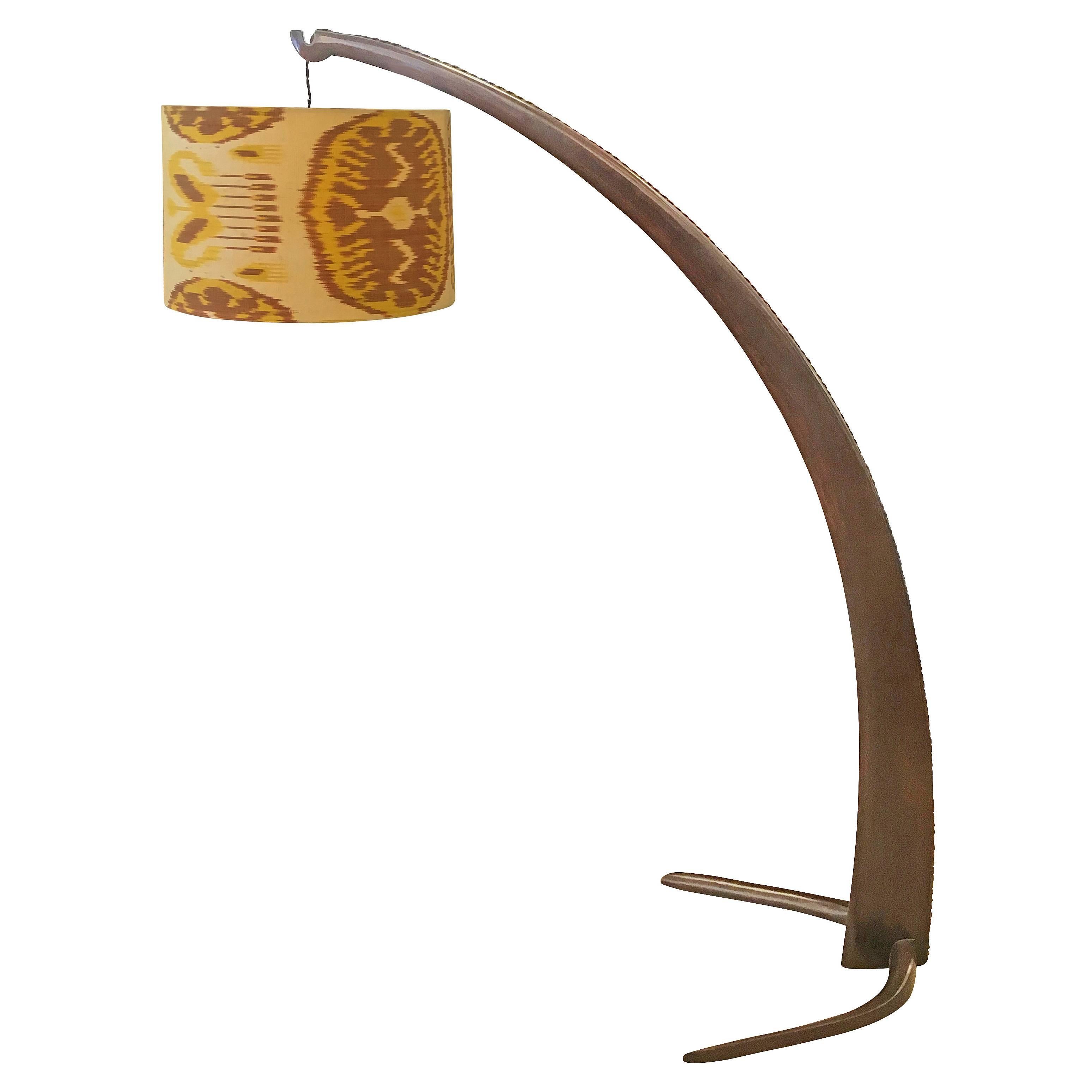Tusk shaped floor lamp made in walnut designed to project light above armchairs. It is the predecessor of the Arco lamp later designed by the Castiglioni brothers. Simple and amazing design. The shade can easily be replaced with a client provided
