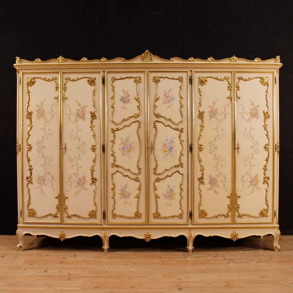 Great Italian wardrobe from the mid-20th century. Furniture in richly carved, lacquered, gilded and hand-painted wood of excellent quality. Six-doors wardrobe, complete with three working keys of exceptional capacity and service. Furniture ideal to