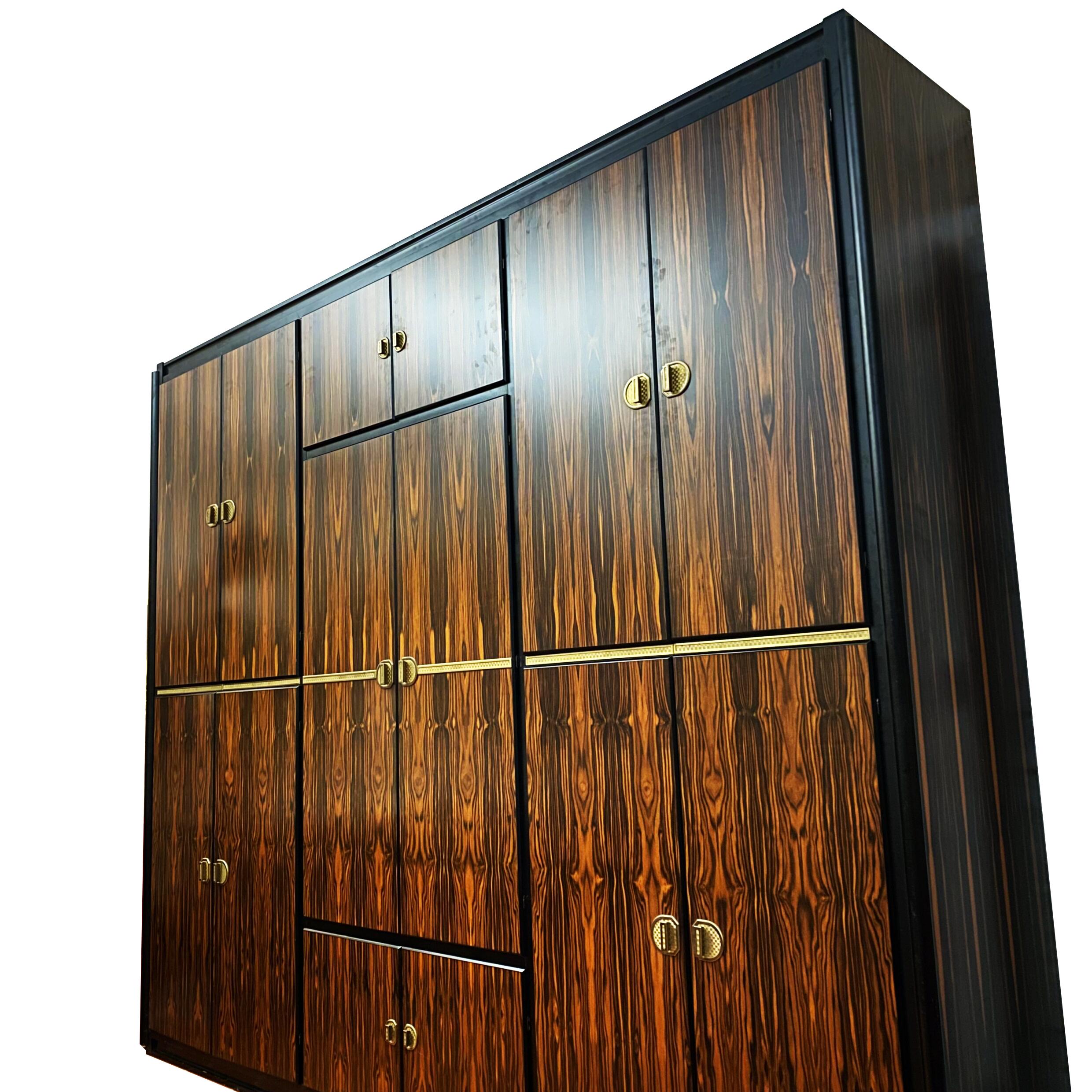 Italian Wardrobe in macassar and brass attributed to Luciano Frigerio, Italy, 1970s.

Massive and rare wardrobe in macassar ebony and Brass elements, consisting of 7 compartments, with central chest of drawers.
The interior is in cherry wood.
A