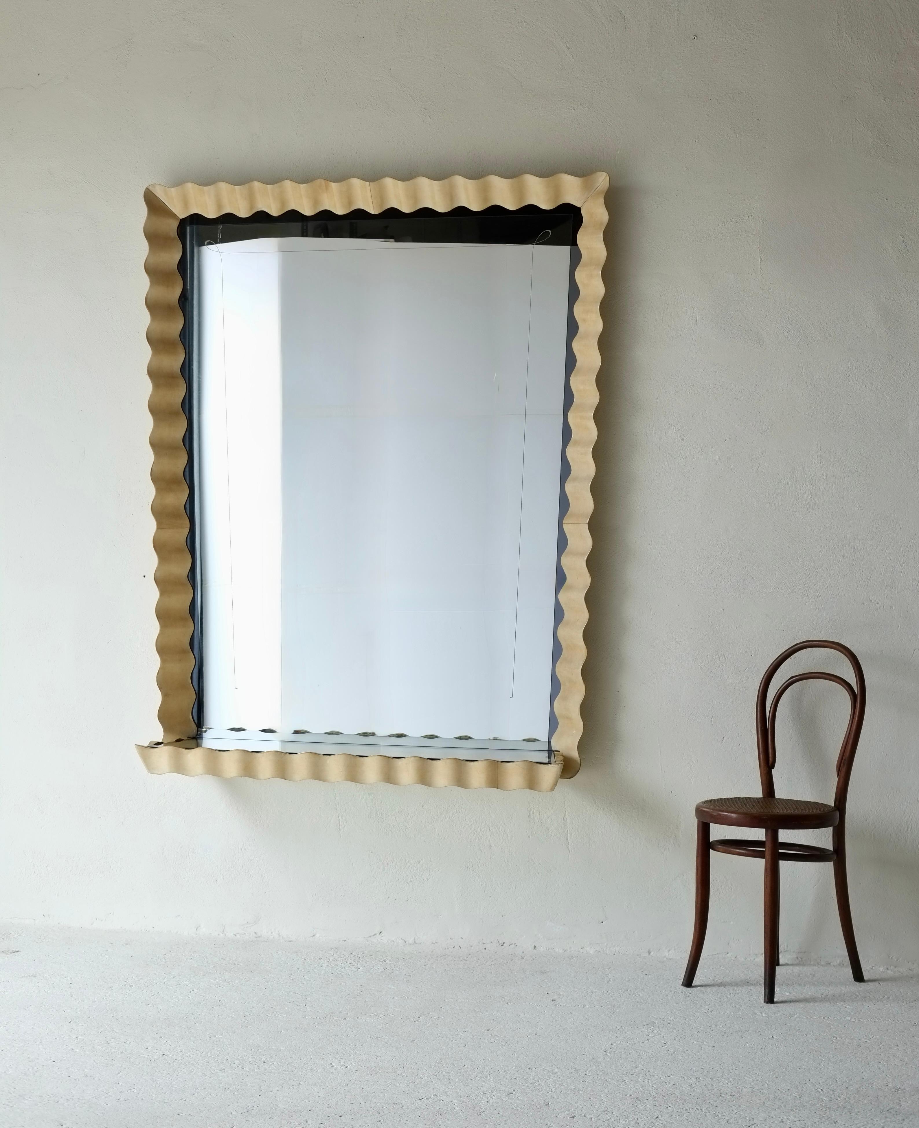 A magnificent and extremely large wavy mirror and glass shelf attributed to Valzania. 

Italy, circa 1950's.

The frame is made of parchment covered wood with an decorative etched mirror and glass shelf. 

In very good condition for it's age with no