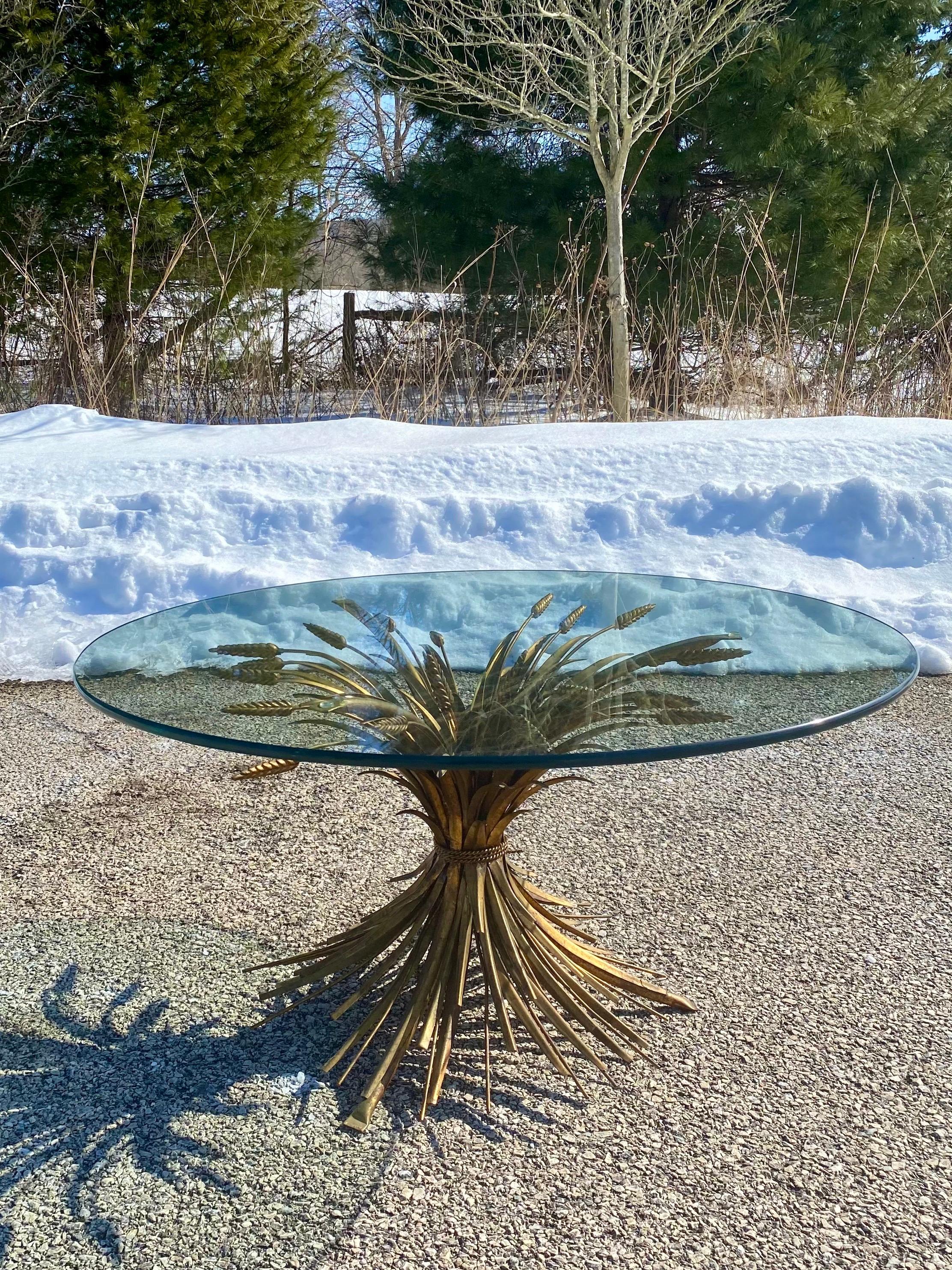 Italian Hollywood Regency wheat sheaf coffee table. This sculptural cocktail table features a gilt metal base with metal rope detailing and a removable clear glass round top. Coco Chanel had a similar table displayed in her Place Vendo^me apartment