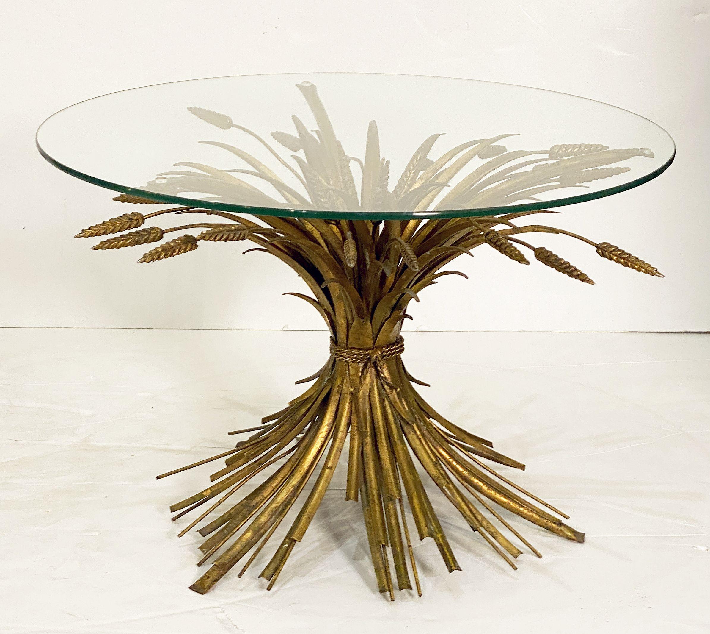 A fine Italian wheat sheaf cocktail or coffee table (or low table) from the Hollywood Regency era, featuring a round glass top set upon a beautifully designed and constructed sheaf of wheat metal base, with original gilt finish. 

Perfect for use as