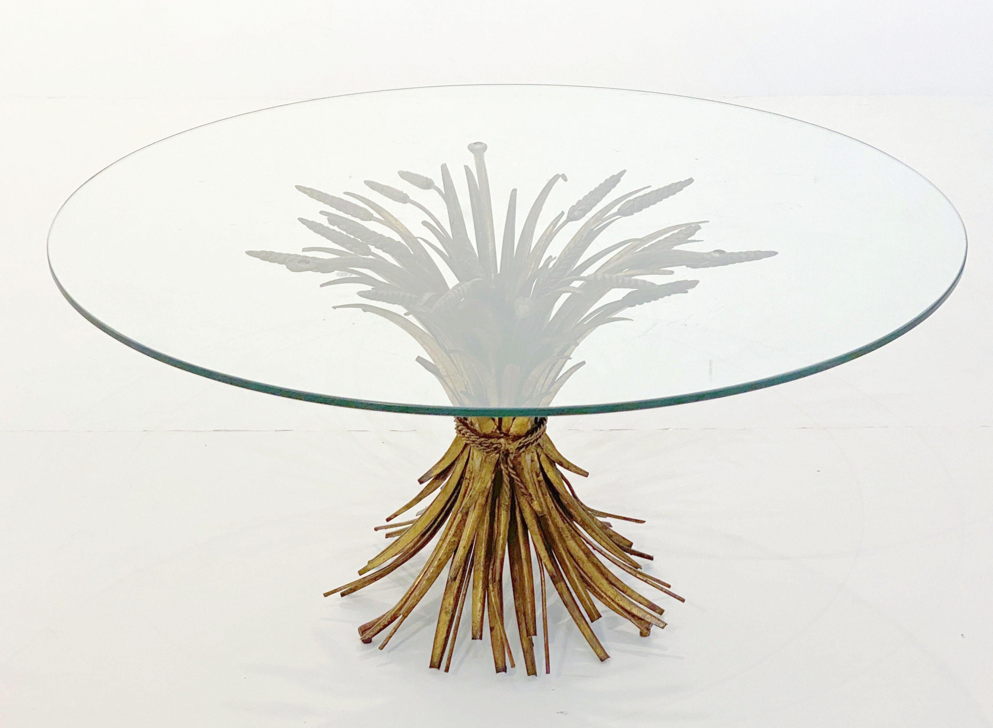 A fine Italian wheat sheaf cocktail or coffee table (or low table) from the Hollywood Regency era, featuring a round glass top set upon a beautifully designed and constructed sheaf of wheat base, with original gilt finish. 

Perfect for use as an