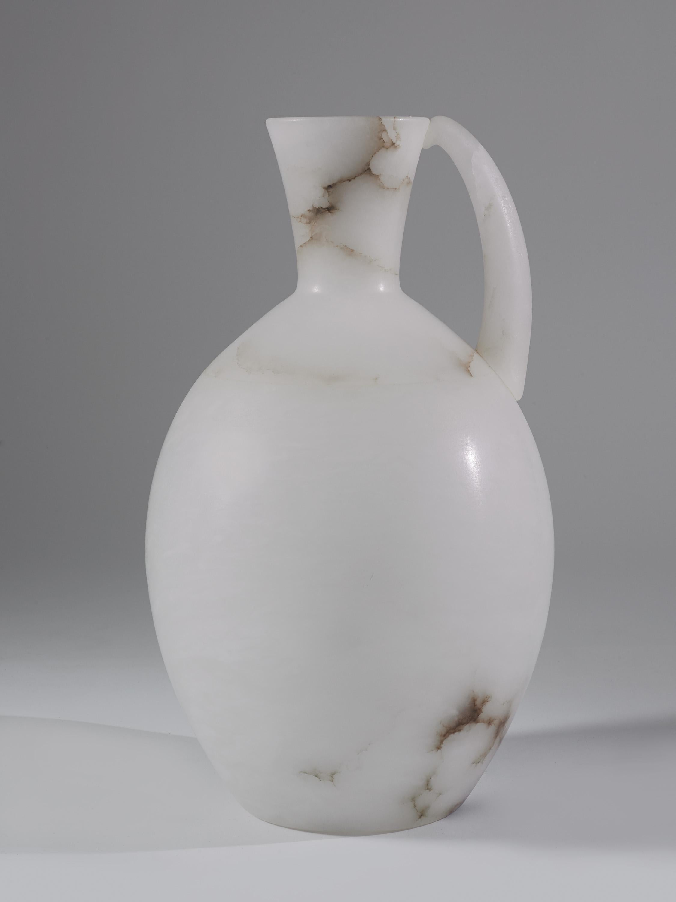 Very impressive large jug sculpted from the purest alabaster found in Italy sculpted by Una Manicci. White with beautiful natural grey vein, inspired by the egyptian clay vessels used to store and transport water. A unique piece made exclusively for