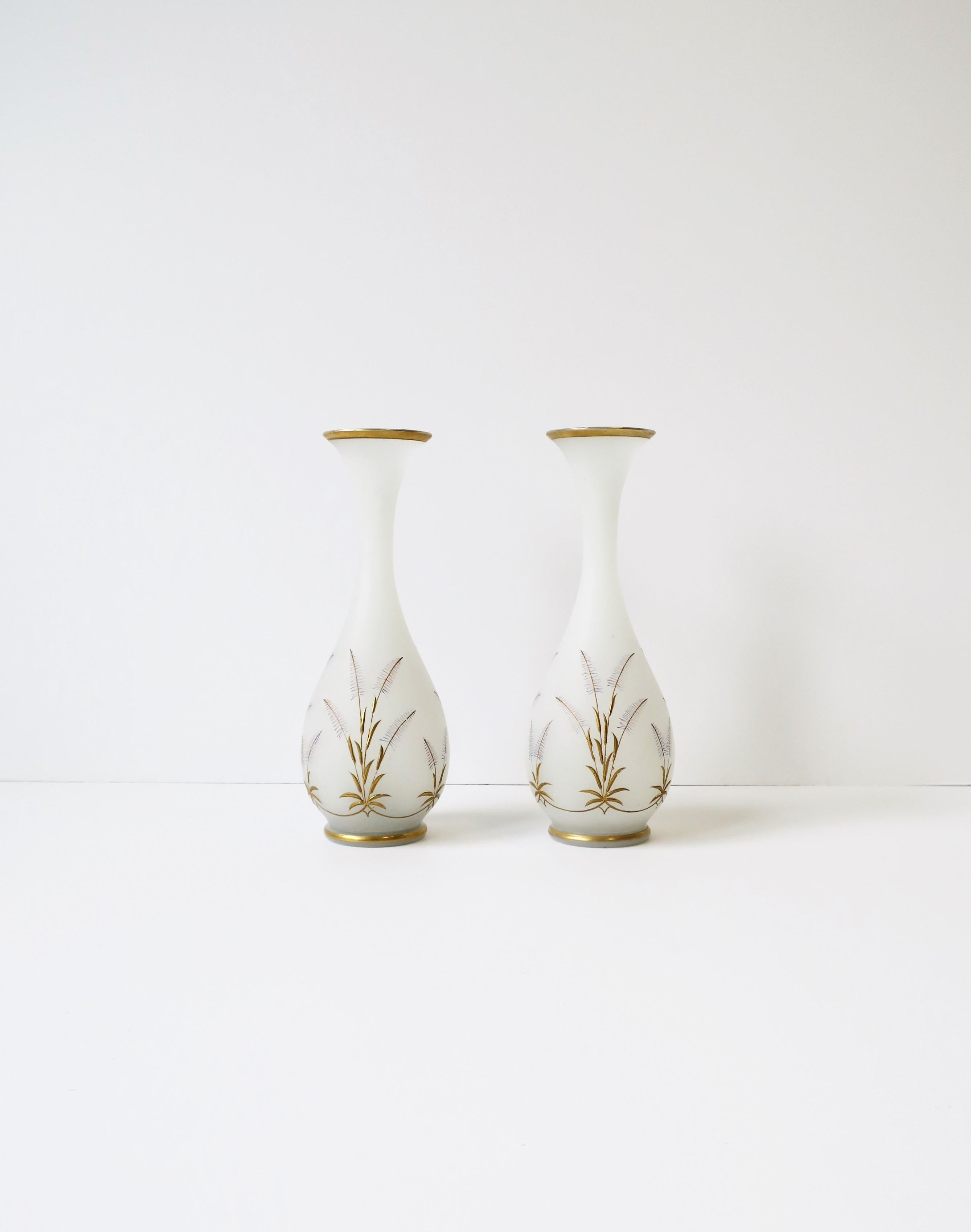 A beautiful pair of Italian white opaline and gold glass vases, circa early-20th century, Italy. Vases are white opaline matte exterior with a raised gold sheef-of-wheat relief design. A gold band a top and bottom edge as well. A beautiful set as