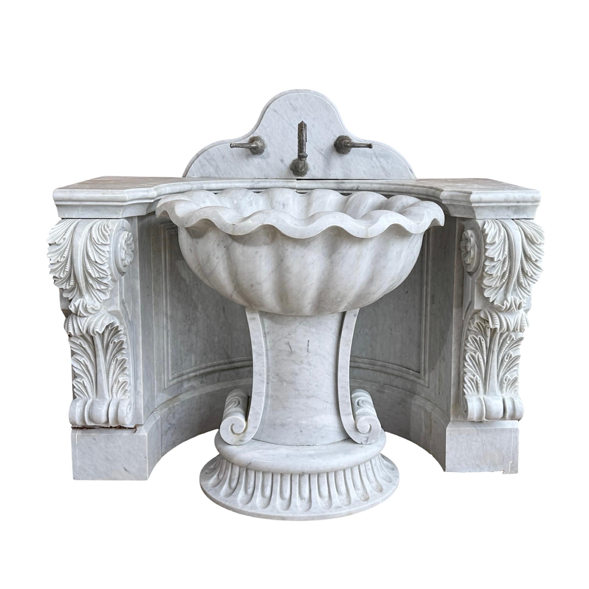 This stunning Italian White Carrara Marble Wall Sink is a 19th-century masterpiece, beautifully hand-carved in the Louis XVI style. The intricate carvings throughout the sink add a touch of elegance to any bathroom. The connecting wall base that