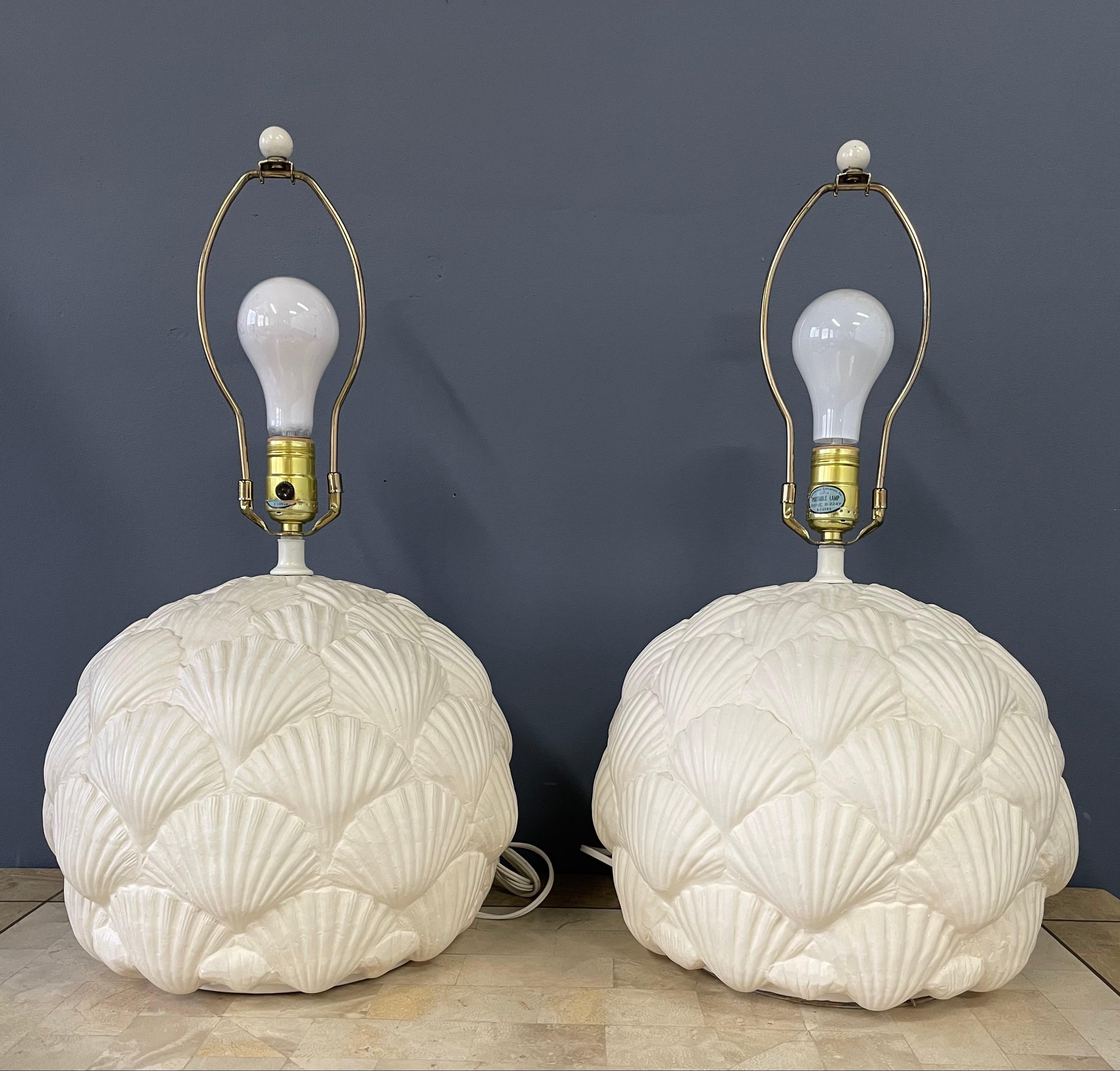 Lovely pair of lamps with an intricate seashell motif. These lamps are ceramic and in wonderful condition.