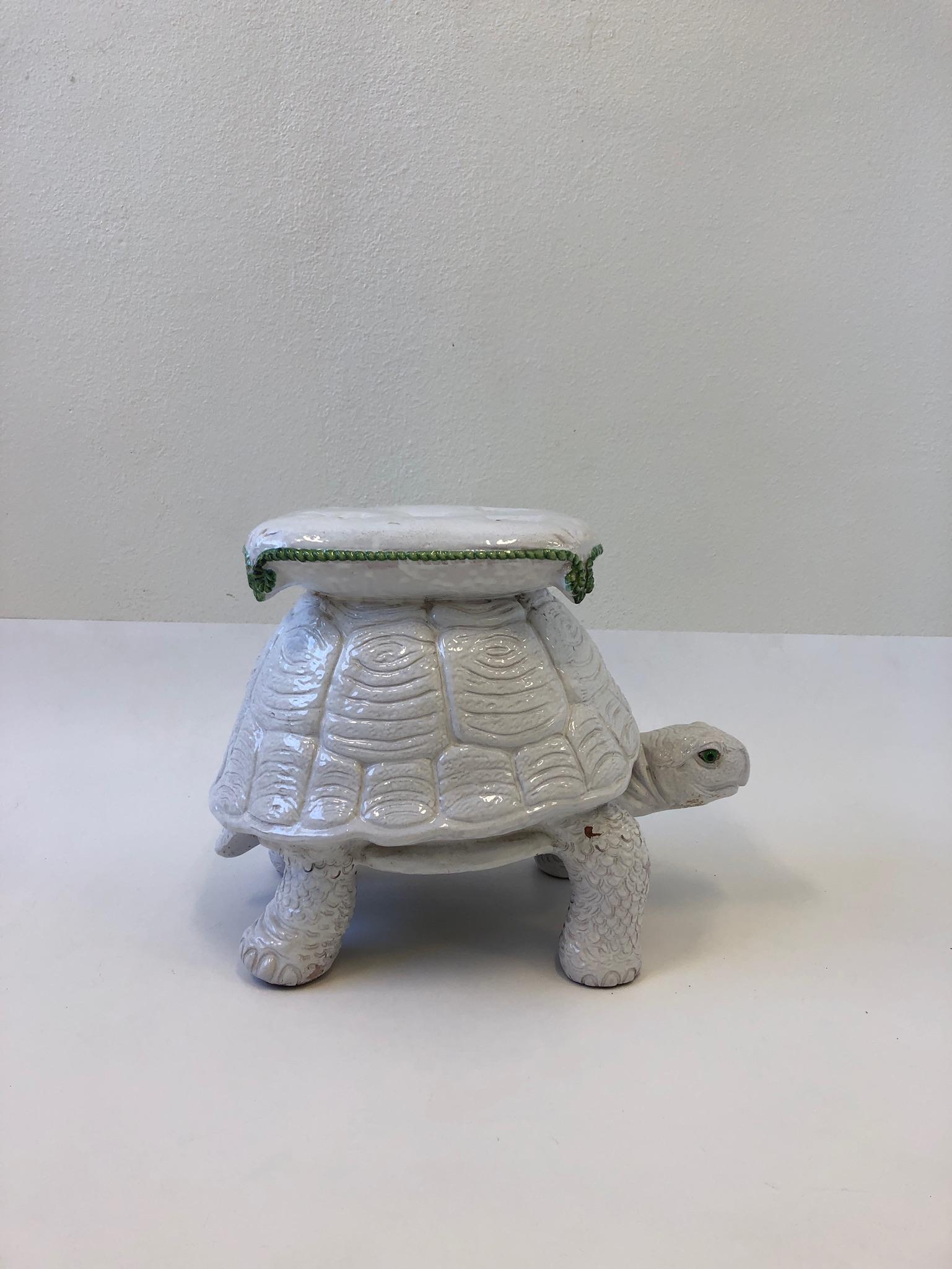 A whimsical 1970s Italian ceramic tortoise with a pillow on top garden stool. It can be used as a side table or a stool. The stool is constructed of white glazed terracotta.
 