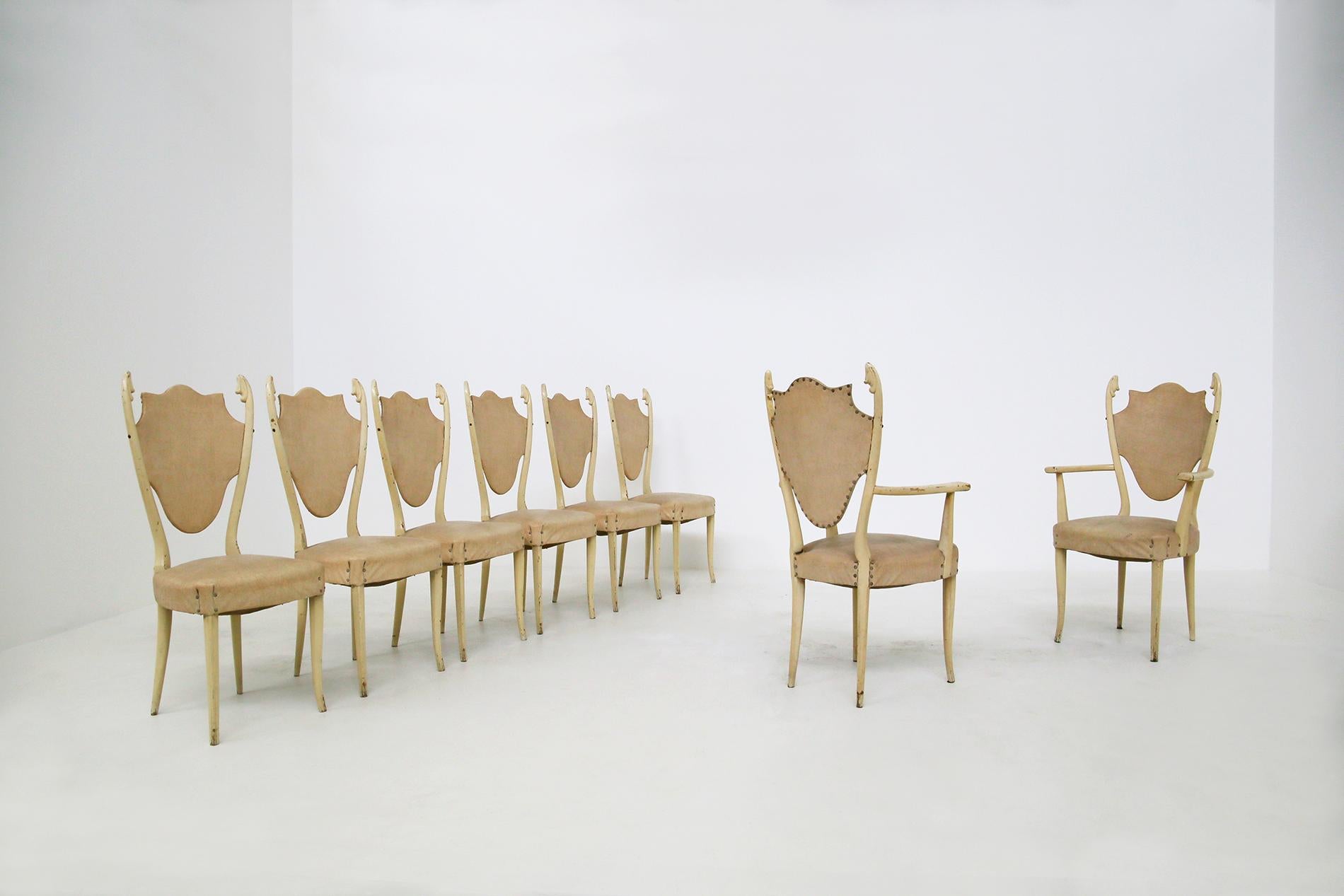 Sculptural Italian chairs of the 1950s, designed by Carlo Enrico Rava. The chairs are in white lacquered ashwood. The set consists of two table heads and four diners. Their eccentricity is its wood carved in the tips of each seat, almost reminiscent