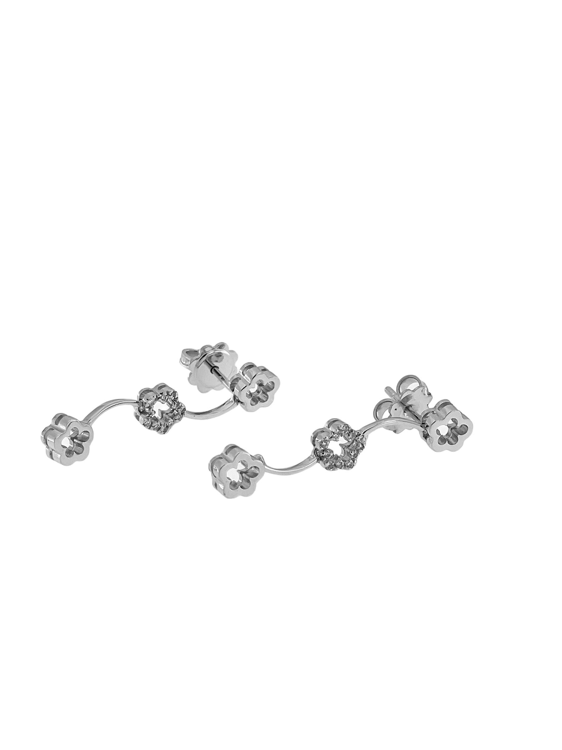 Ces boucles d'oreilles pendantes en or blanc italien sont un magnifique mélange d'élégance moderne et de design floral délicat. Réalisées en or blanc luxueux 18 carats, ces boucles d'oreilles présentent un gracieux style pendentif qui ajoute une