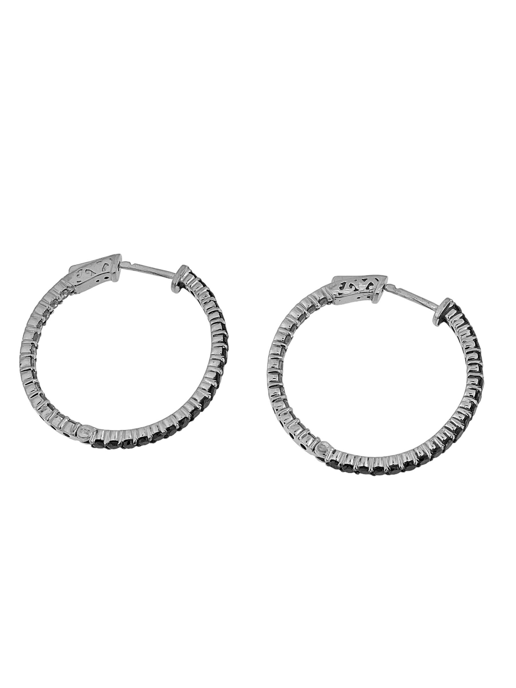 The Italian White Gold Hoop Earrings with Black and White Diamonds are a stunning and sophisticated addition to any jewelry collection. These earrings are crafted from luxurious 18kt white gold, offering a sleek and modern design that combines the