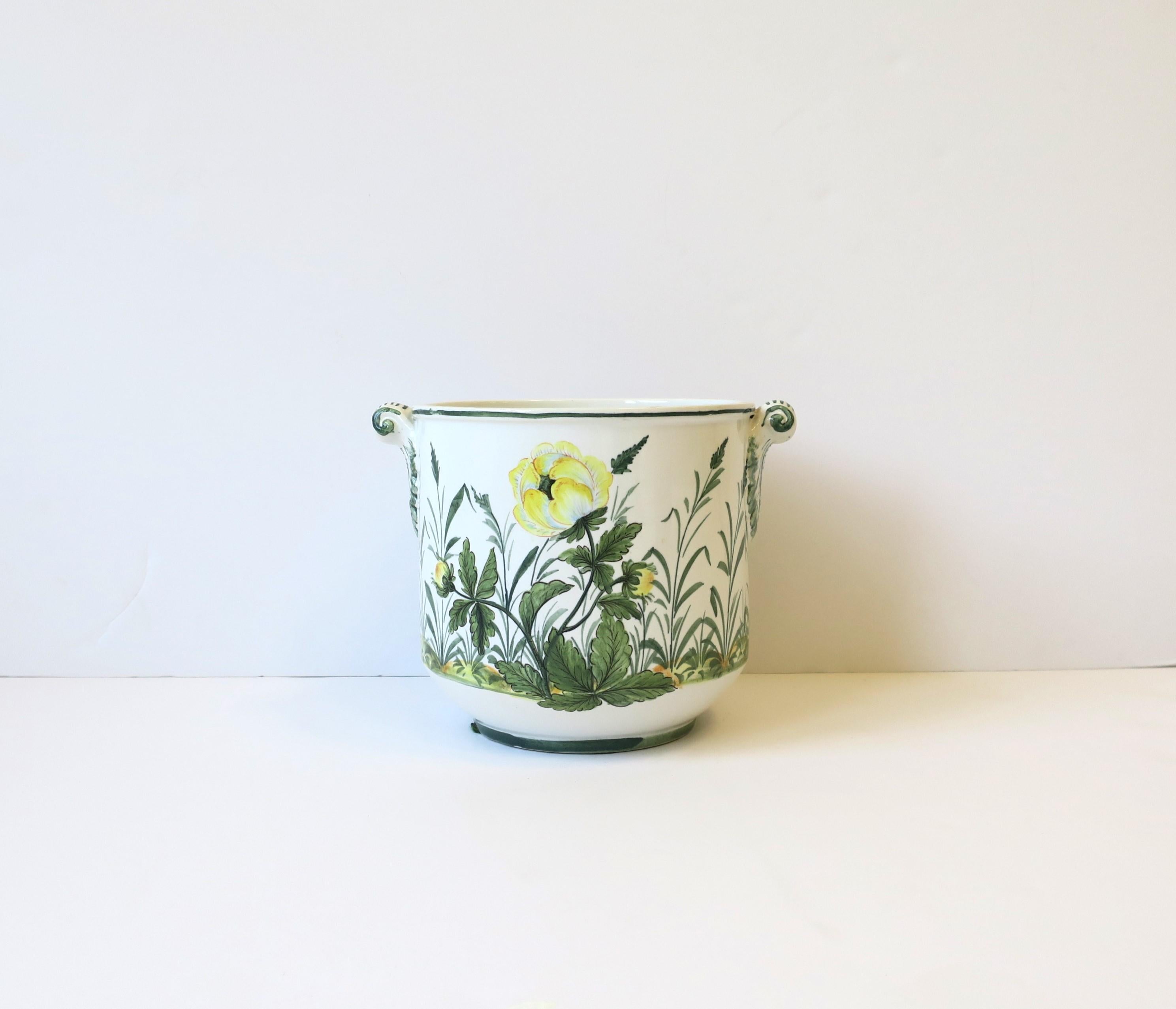 An Italian white ceramic green and yellow flower or plant pot holder cachepot jardiniere planter with yellow and green flowers, leaves and tall grass, circa late-20th century, Italy. Piece has a design on front and back with scroll handles on sides.