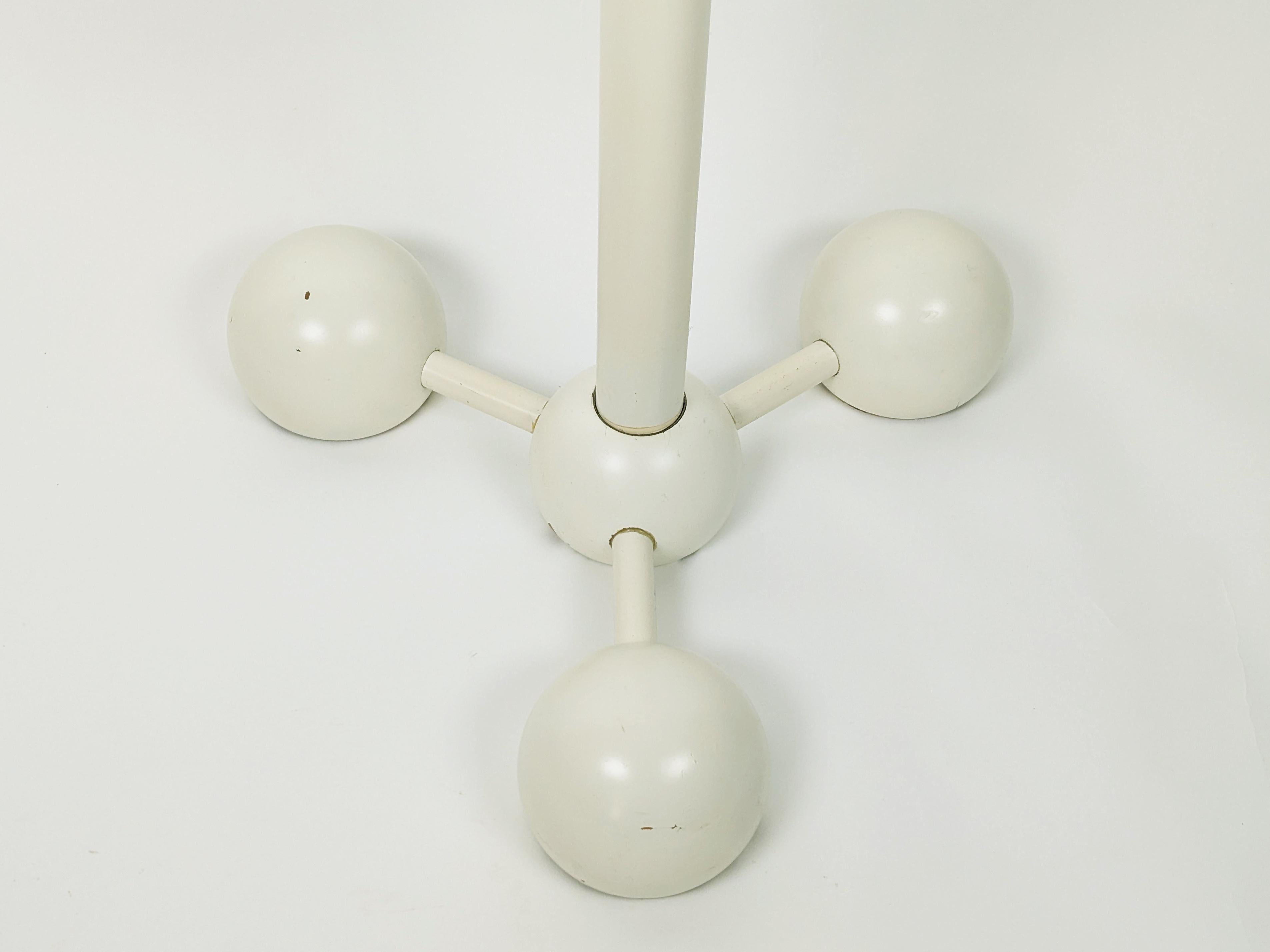 Porte-manteau autoportant sculptural en bois laqué avec bras réglables.
Les trous placés à différentes hauteurs le long de la tige principale permettent de personnaliser la position des bras horizontaux : En dévissant l'un des 2 boutons, ils peuvent