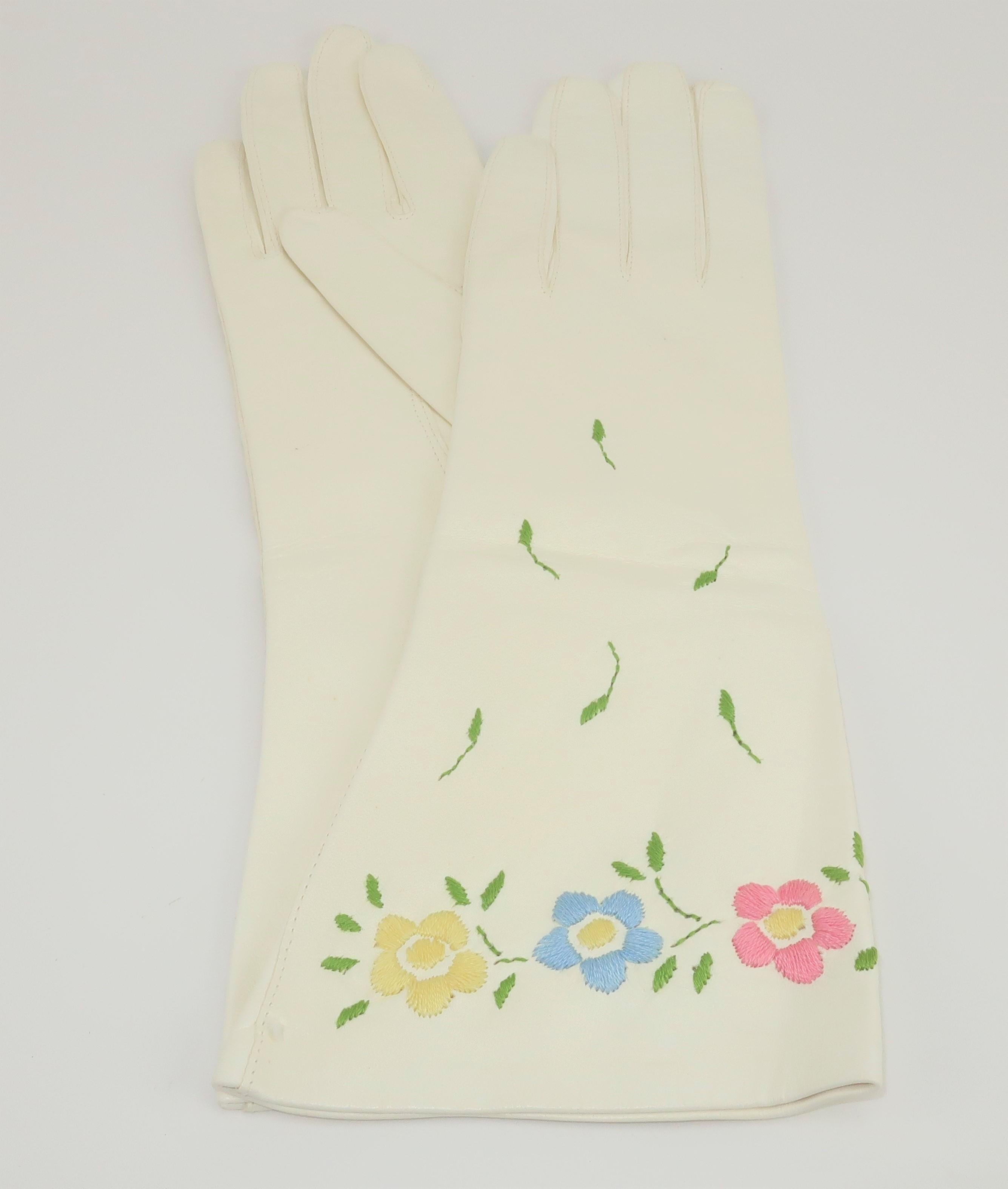 Lovely 1950's Italian white leather gloves with pastel floral embroidery in shades of yellow, blue, pink and green.  The gloves were previously owned though never worn with a manufacturers stitch remaining intact at the cuff.  An elegant Spring and