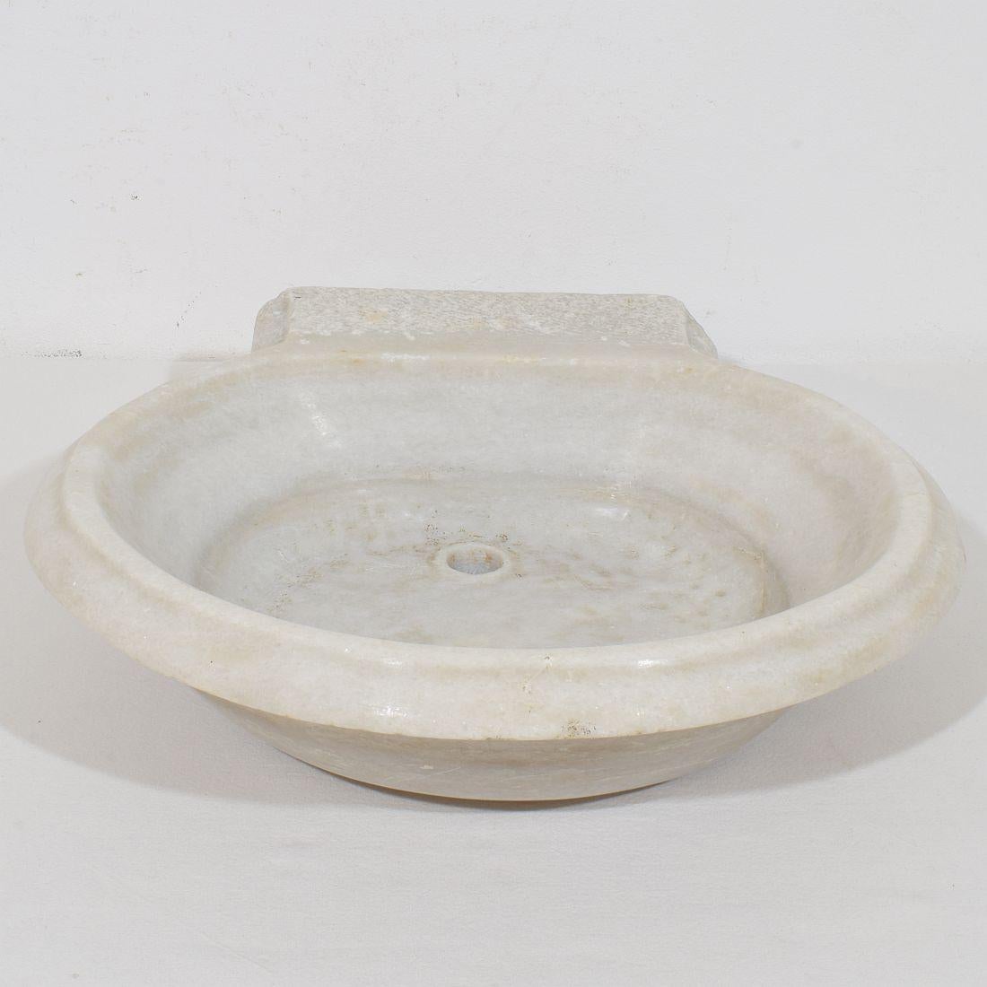 Schönes und sehr seltenes handgeschnitztes Wasserbecken aus weißem Marmor, Italien, um 1750-1800. Verwittert.
H:11cm  B:38cm T:32,5-38,5cm 