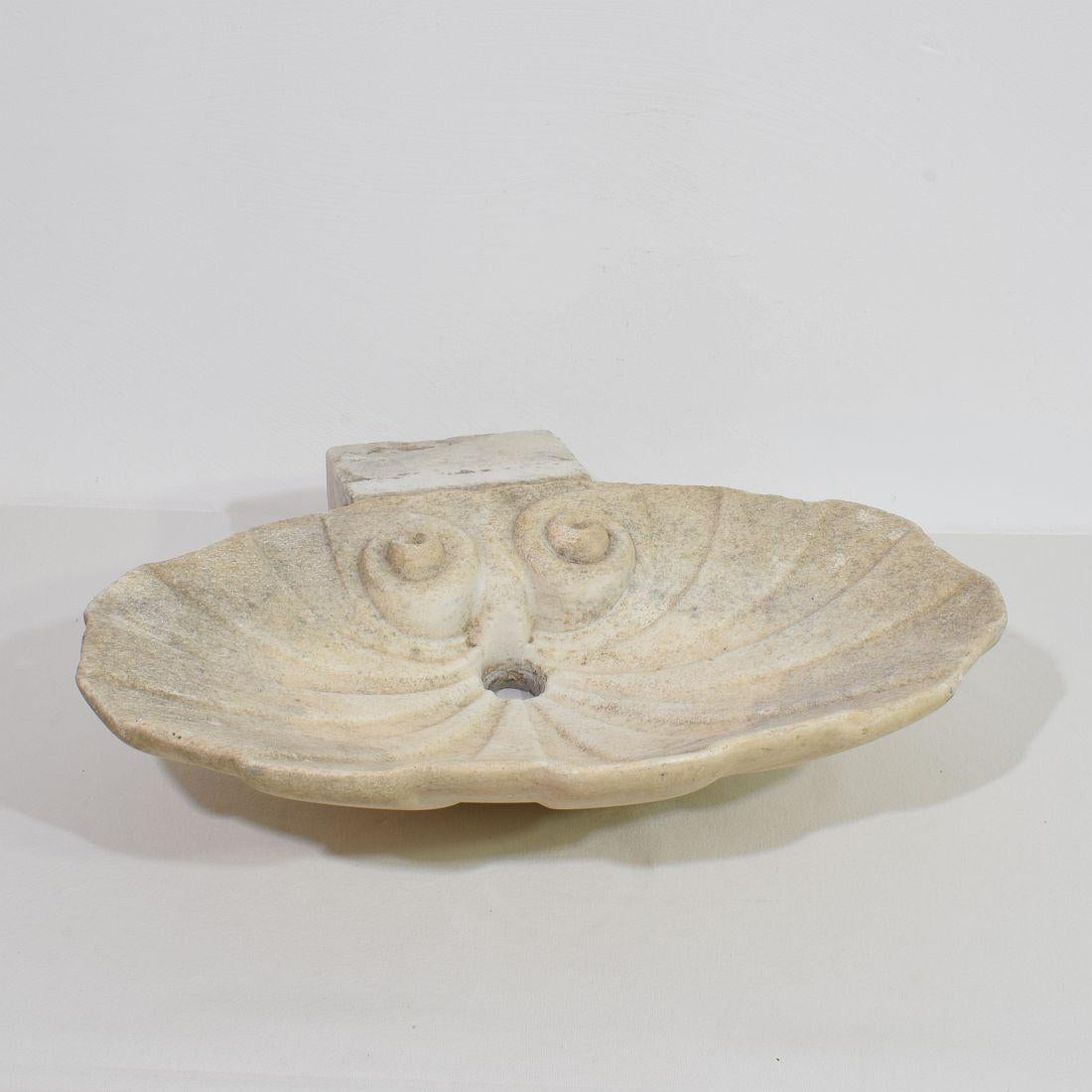 Stunning handcarved white marble water basin or sink in the form of a baroque shell. 
Beautiful weathered original period piece from an old estate.
Italy, circa 1750. Weathered. H:12cm  W:54cm D:39-49cm 