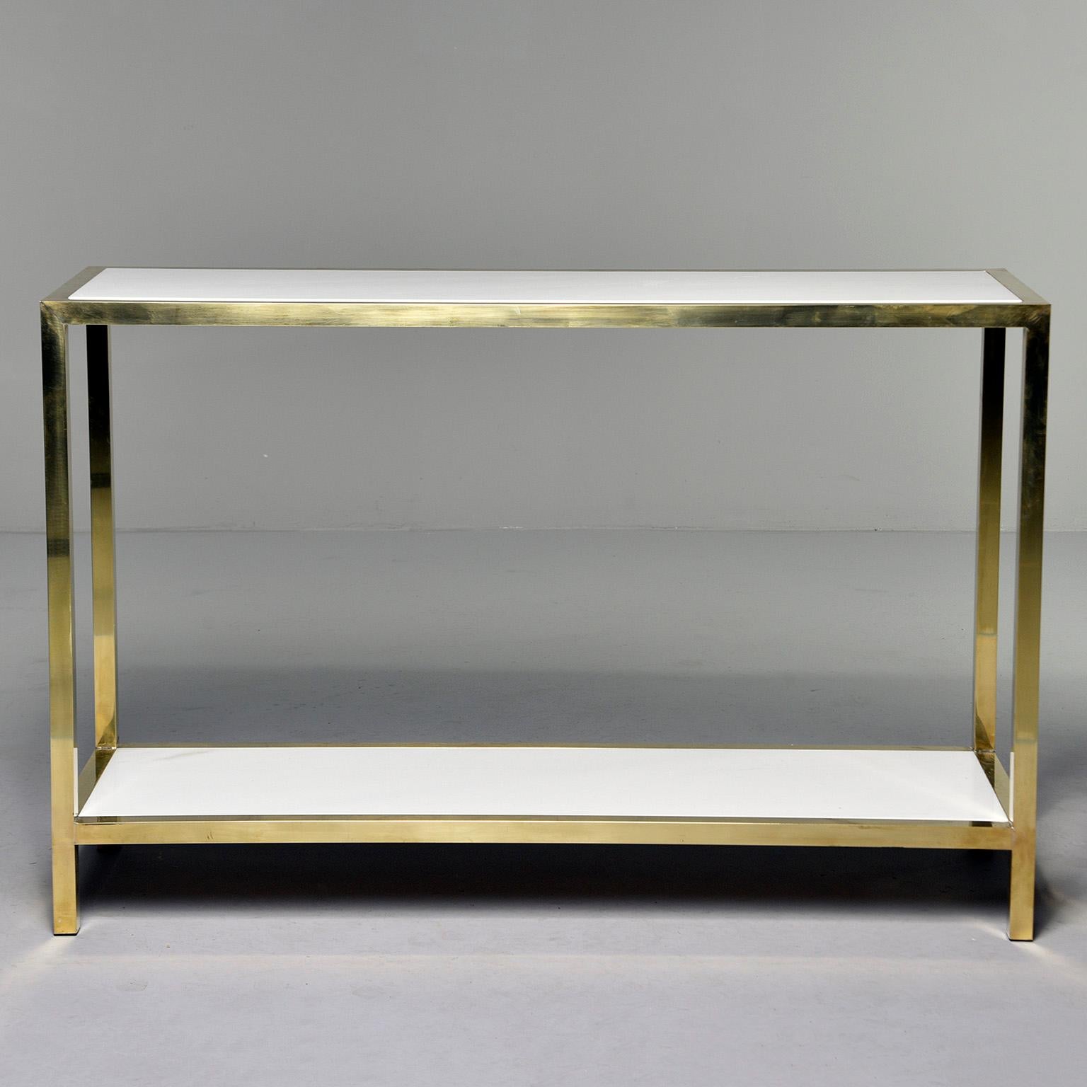 Found in Italy and presumed to be Italian made, this circa 2010 console table has Classic lines with a polished brash frame and two tiers of Italian white marble. Two consoles of this style and size available at the time of this posting. Sold and