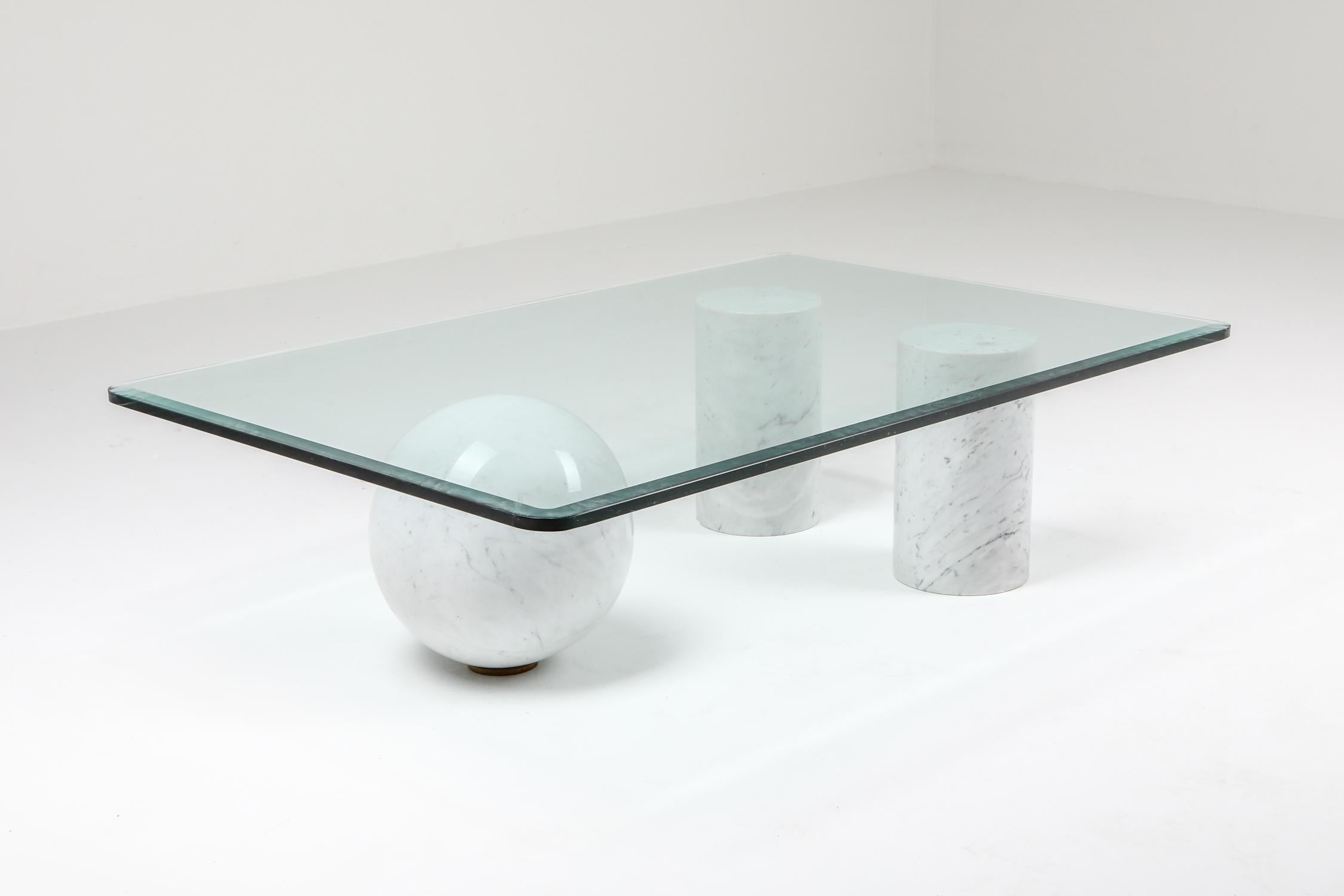 Post-modern Italian coffee table designed by Massimo Vignelli for Casigliani. This features a marble sphere and two cylinders, on which a 1/2” thick glass top rests. 
Quite a dynamic use of Carrara marble and shapes

The combination of precious