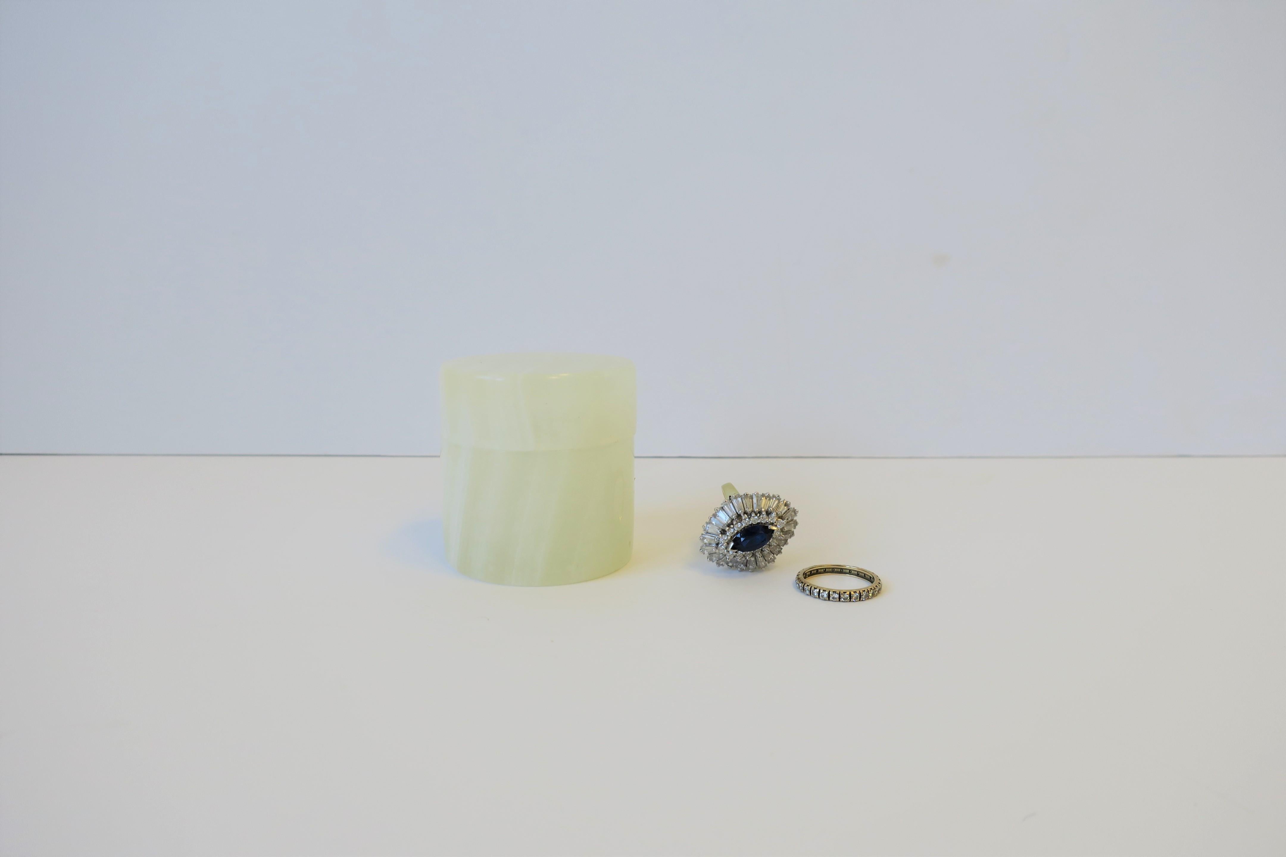 Eine kleine runde Dose aus weißem Onyxmarmor der 1970er Jahre. Ein großartiges Stück, um kleine Gegenstände auf dem Schreibtisch oder in der Eitelkeit für Büroklammern oder Schmuck, wie Ringe, Ohrringe oder Manschettenknöpfe zu halten. 

Stück