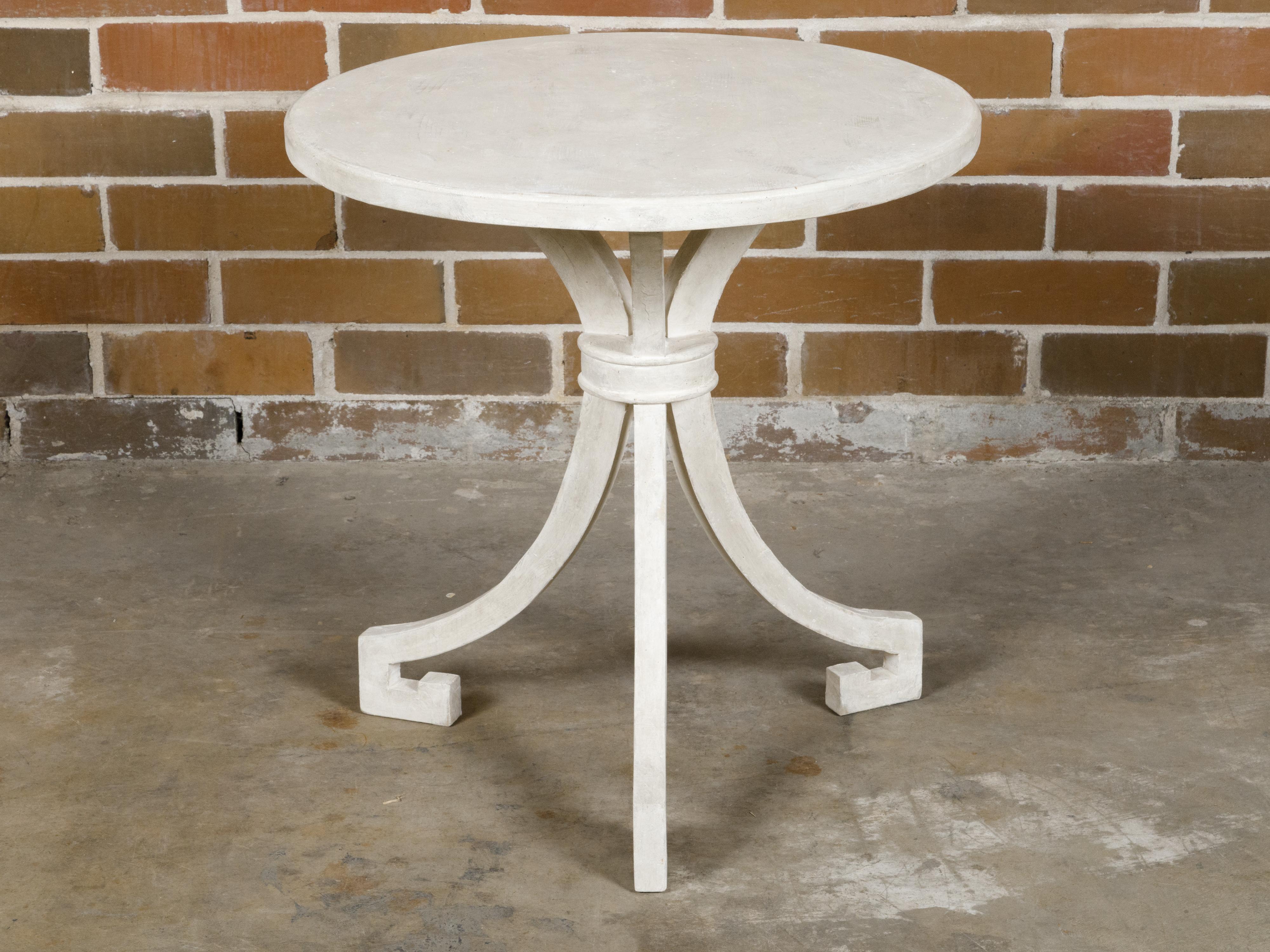 An Italian wooden side table with white painted finish, round top and tripod base. Capturing the essence of Italian craftsmanship, this vintage side table features a round top painted in a serene white finish, supported by a charming tripod base.