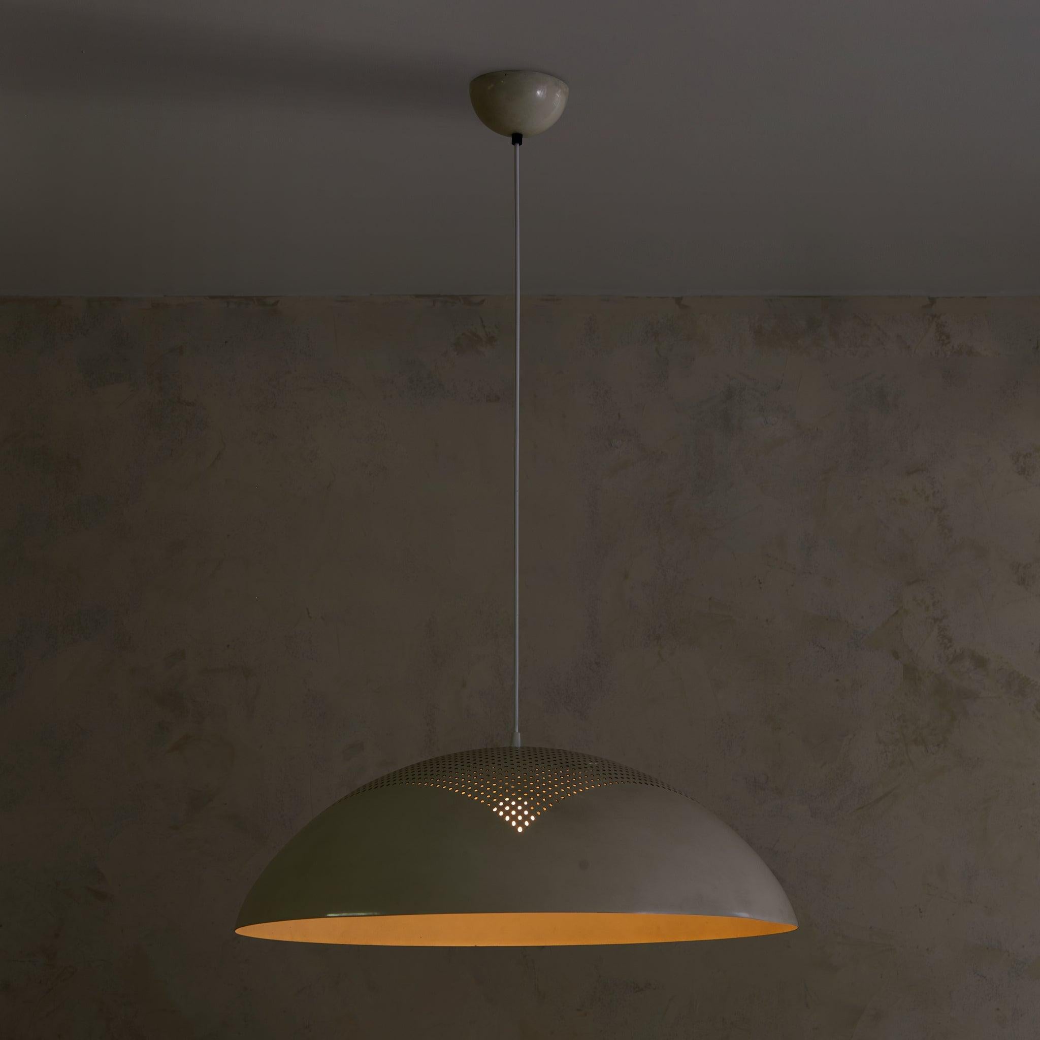 Dieser Anhänger aus den 1970er Jahren, der Pruluce Vicenza zugeschrieben wird, destilliert industrielles Design in eine Form von poetischer Einfachheit. Die breite Kuppel aus weiß lackiertem Metall wird von zarten Perforationen durchbrochen - ein