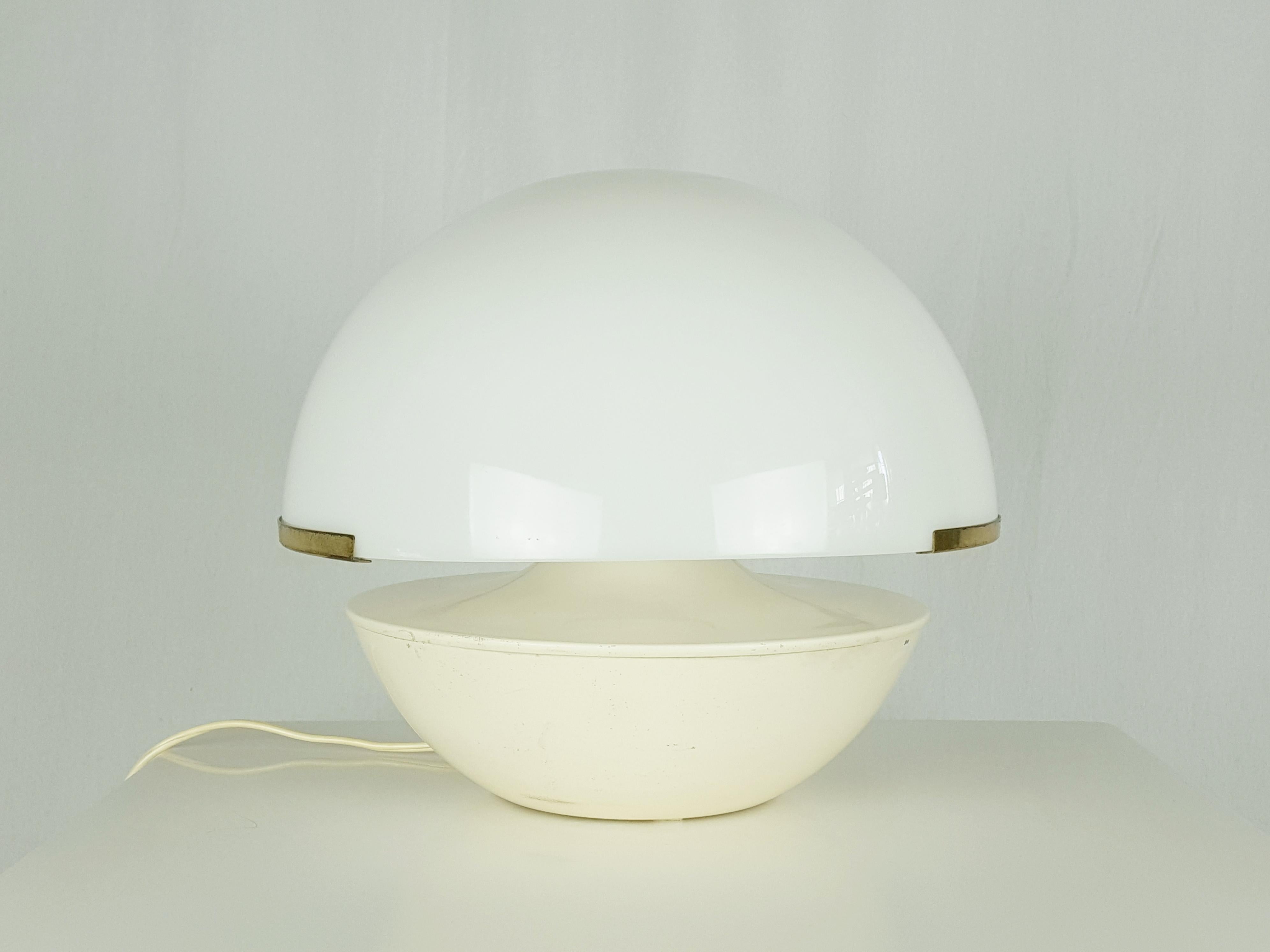 Table lamp produced in the late 1960s in Italy. Ivory white metal body with brass support structure and hemispherical white perspex lampshade. The lampshade is interlocked on the brass structure. Original electrical system with a lamp holder