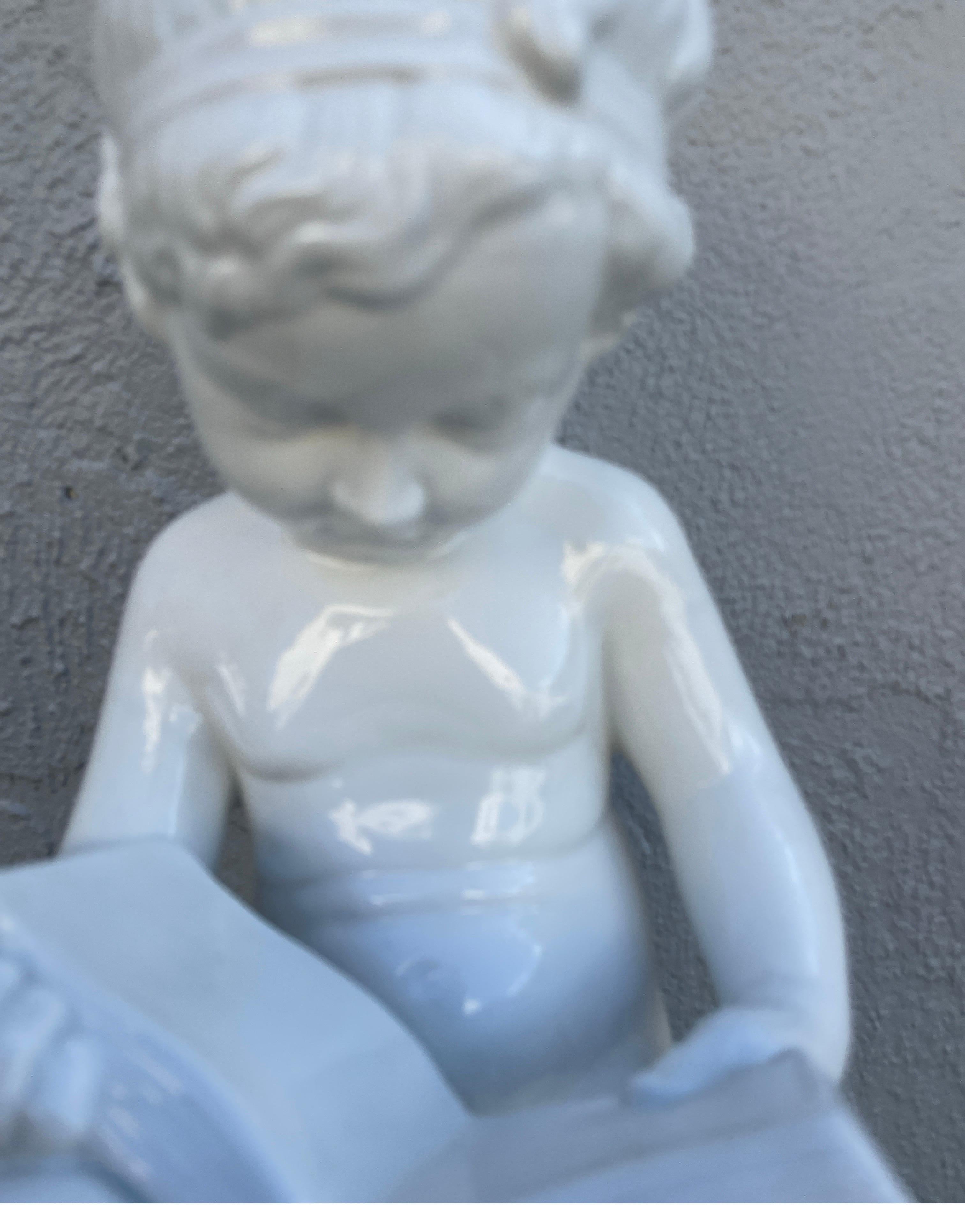 Very sweet white porcelain Italian figurine of an angelic figure seated reading a book.
