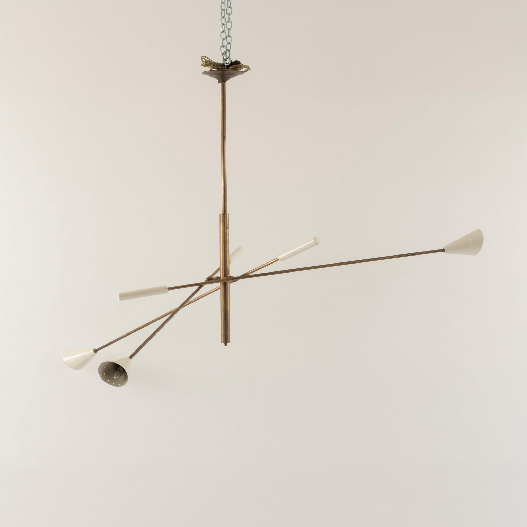 Araña italiana de tres luces Triennale, de color blanco marfil, fabricada en latón, con tres brazos regulables, difusores de forma cónica y reforzada por contrapesos.