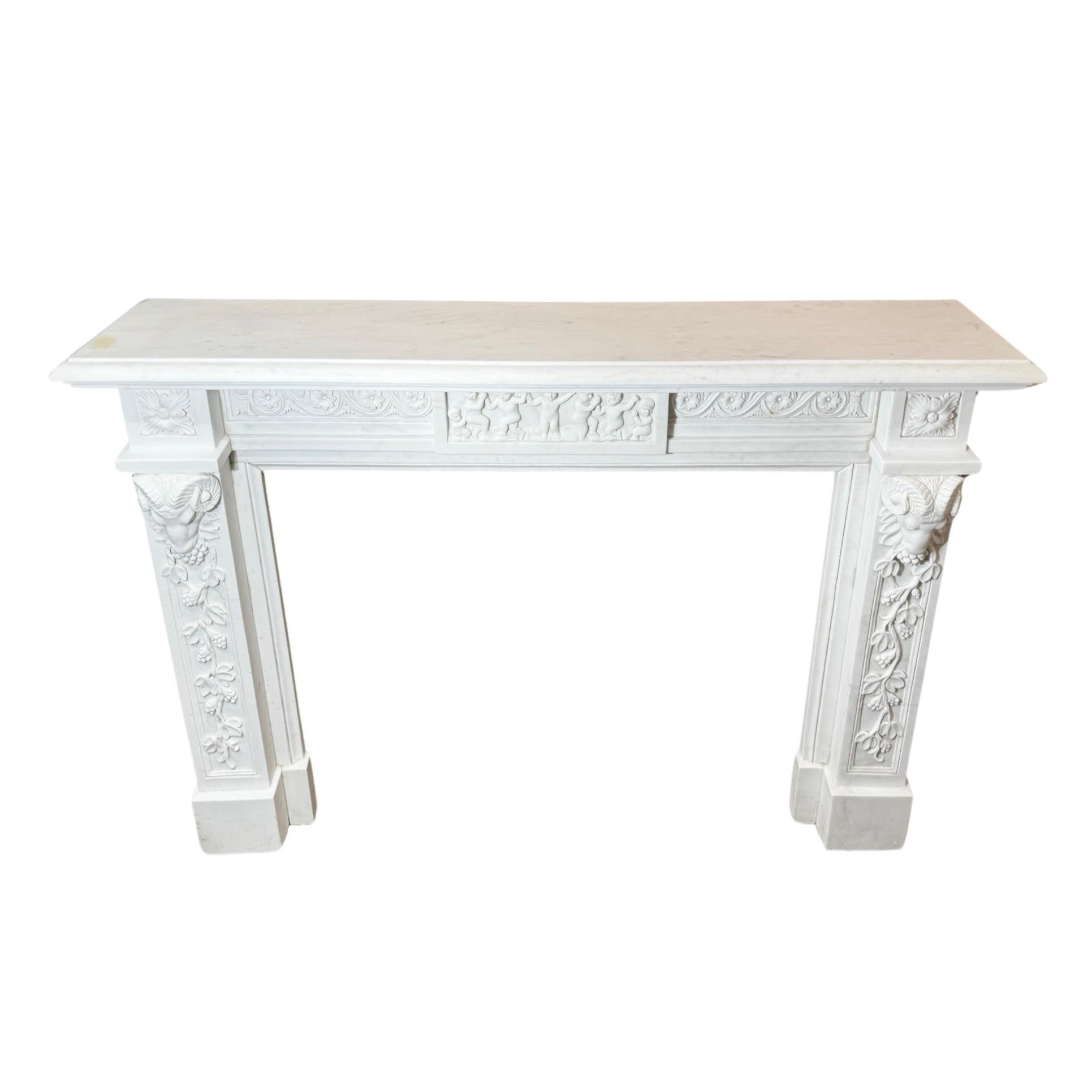 Expertly crafted from beautiful Italian White Veined Carrara Marble, this 18th century Louis the 16th style mantel features intricate cherub and floral carvings, along with rams head carvings on each leg. Elevate your fireplace with this luxurious