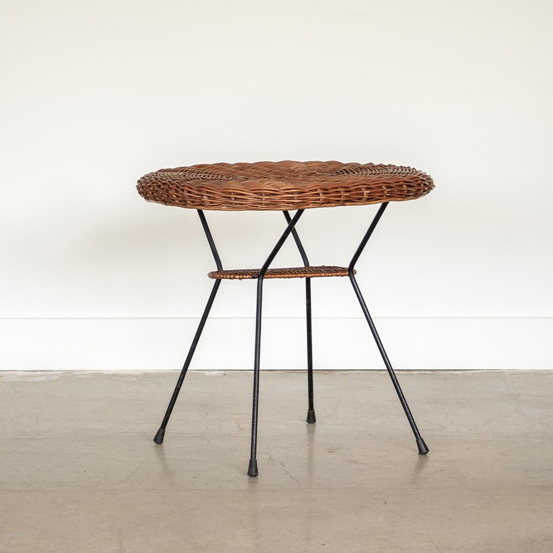 Beautiful oval wicker and iron table from Italy, 1950's. Original wicker table top with 2nd lower wicker shelf. Four angled black iron legs with original finish. Beautiful and functional design.