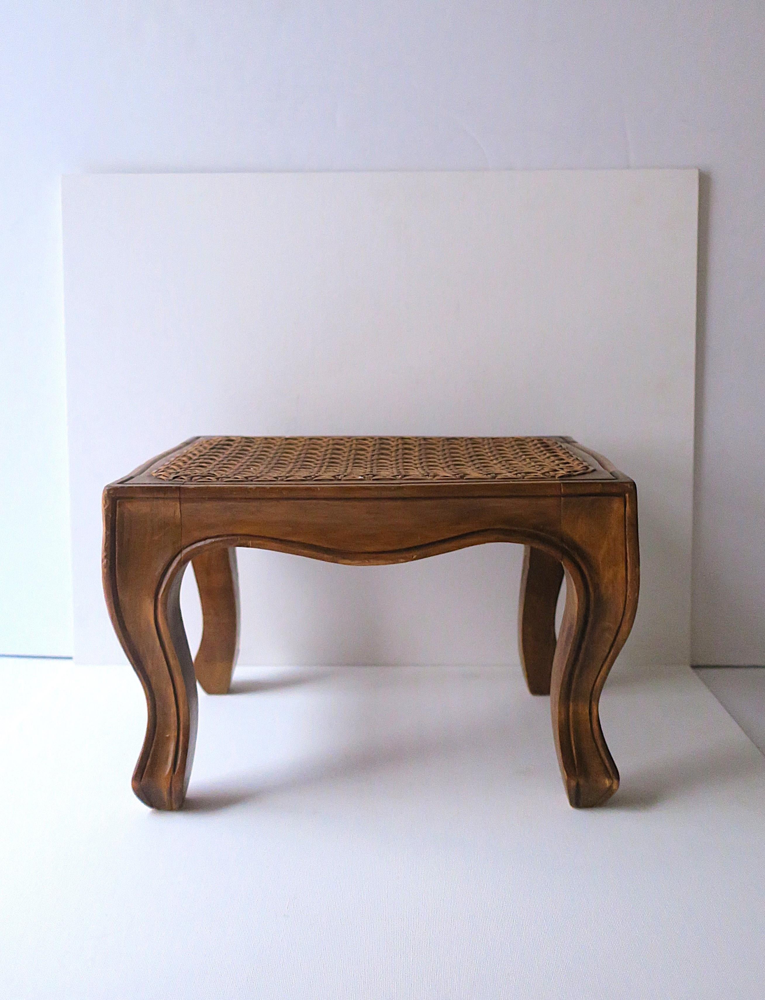 Taburete/reposapiés italiano de madera con tapa de caña, con detalle de talla y pata cabriolé, de estilo rococó, hacia mediados o finales del siglo XX, Italia. La pieza también puede utilizarse como una pequeña mesa baja, siempre que haya un entorno