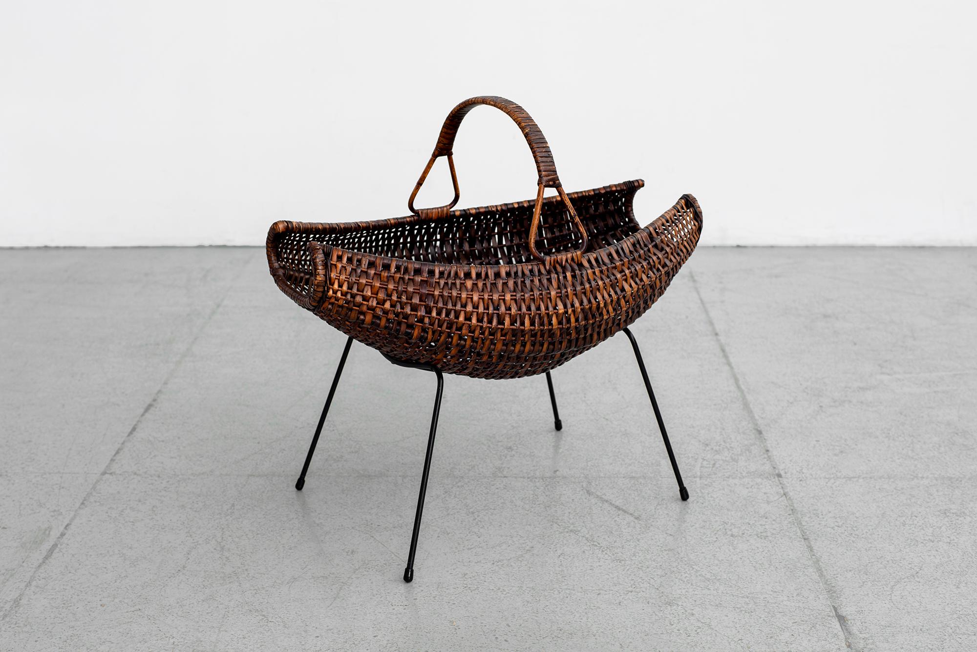 Sweet 1950s Italian wicker catch all with iron base and hammock shape basket with woven handle.
  