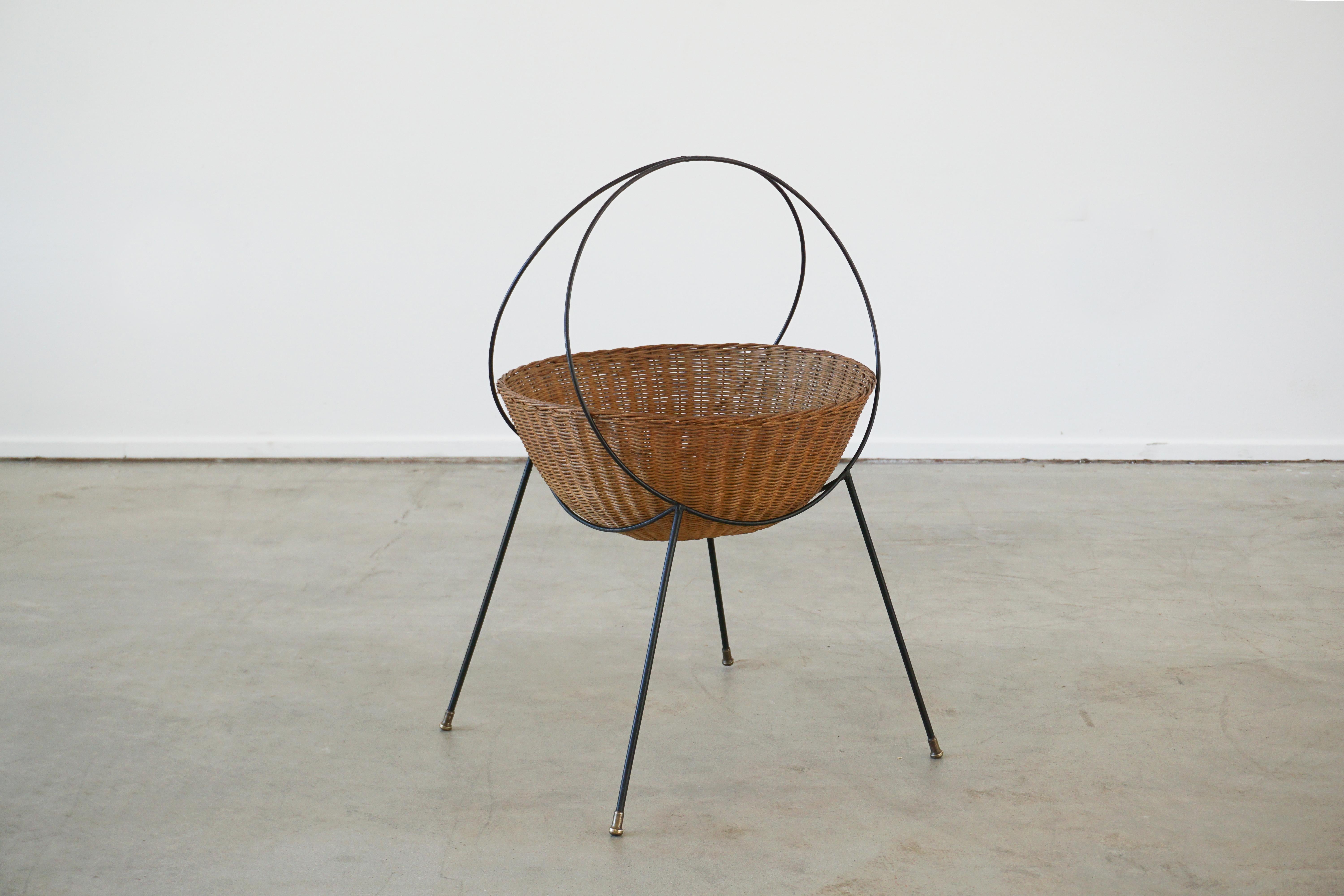 1950's Italian wicker basket cradled on an iron base with brass feet. 
Great for beach house with sun supplies or catch all for any home. 
 