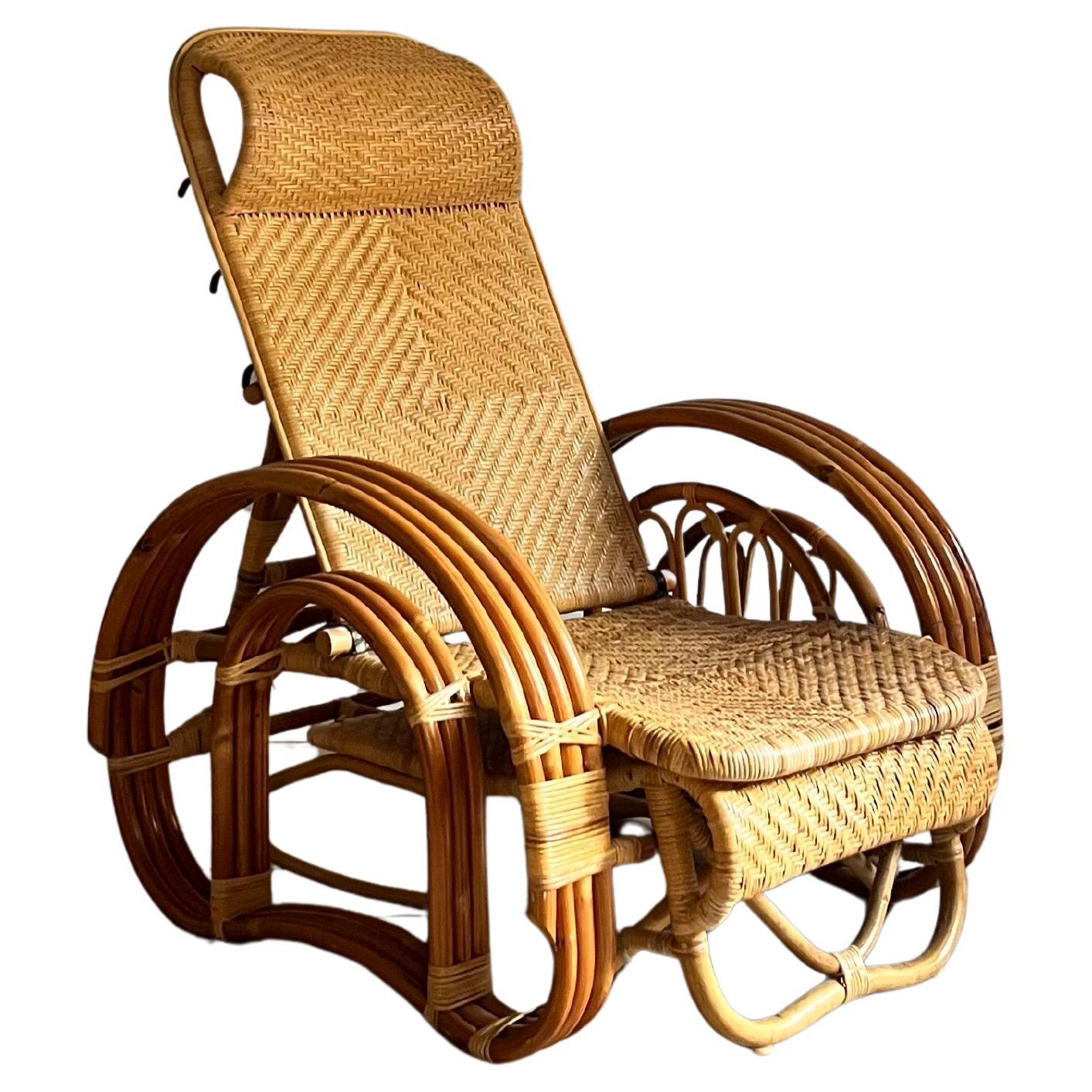 Chaise italienne en bambou et osier avec pouf escamotable. 

Grands accoudoirs incurvés en bambou, tandis que l'assise et le dossier de la chaise présentent un cannage détaillé.

Avec porte-journaux/livres sur le côté et dossier haut à 3 positions.