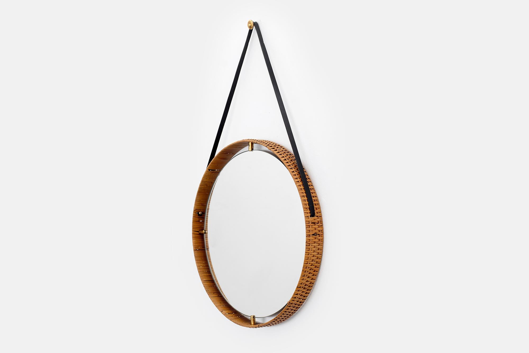 Italian mirror with wrapped wicker frame and brass peg detailing.
Hangs on black leather strap with brass tabs.
36