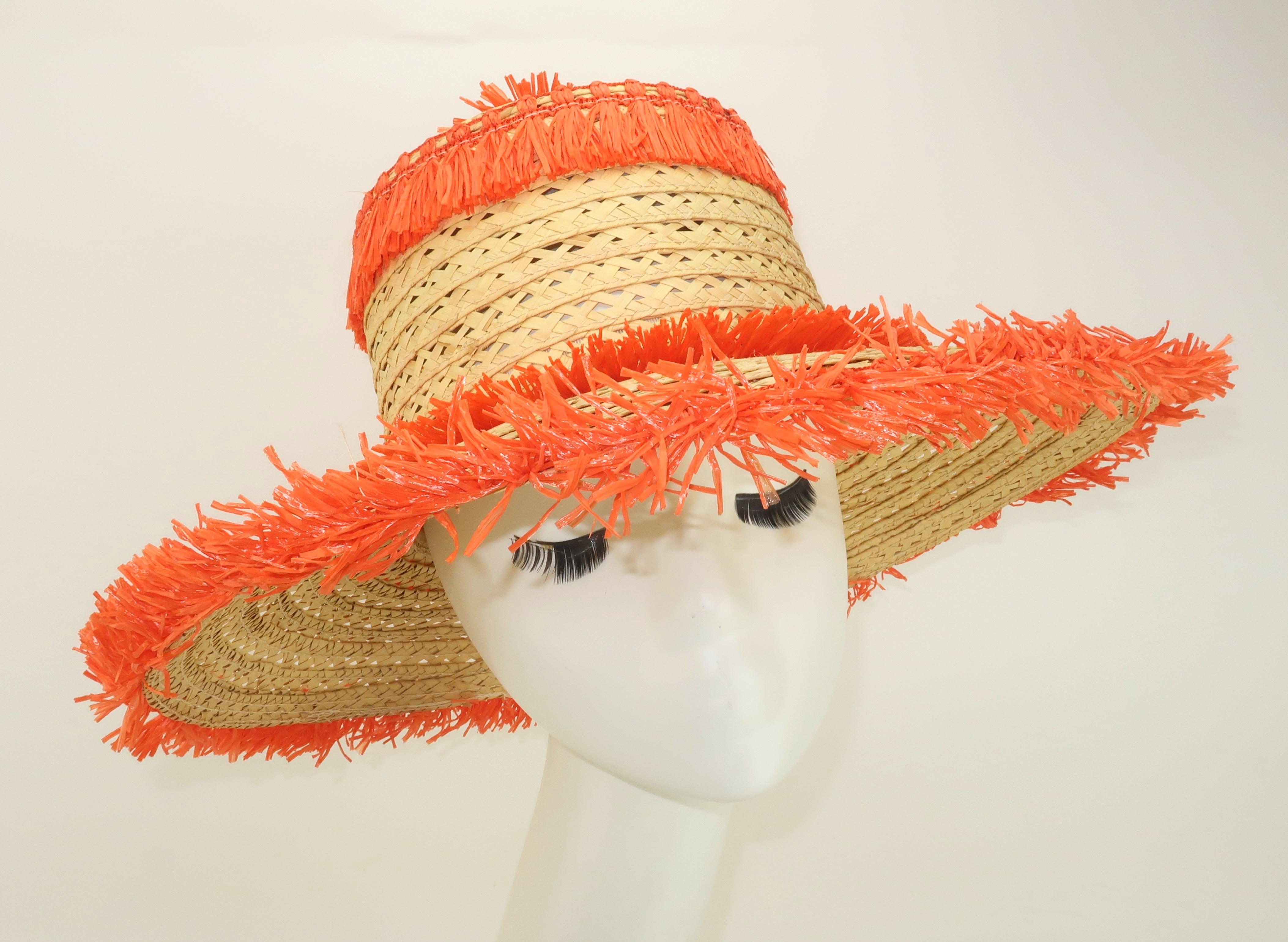Es ist Zeit für ein bisschen Spaß in der Sonne! Italienischer Strohhut aus den 1960er Jahren mit breiter Krempe und skurriler, orangefarbener Bastdekoration, einschließlich einer Blumenbommel am oberen Ende der Krone. Das offene Geflecht des Strohs
