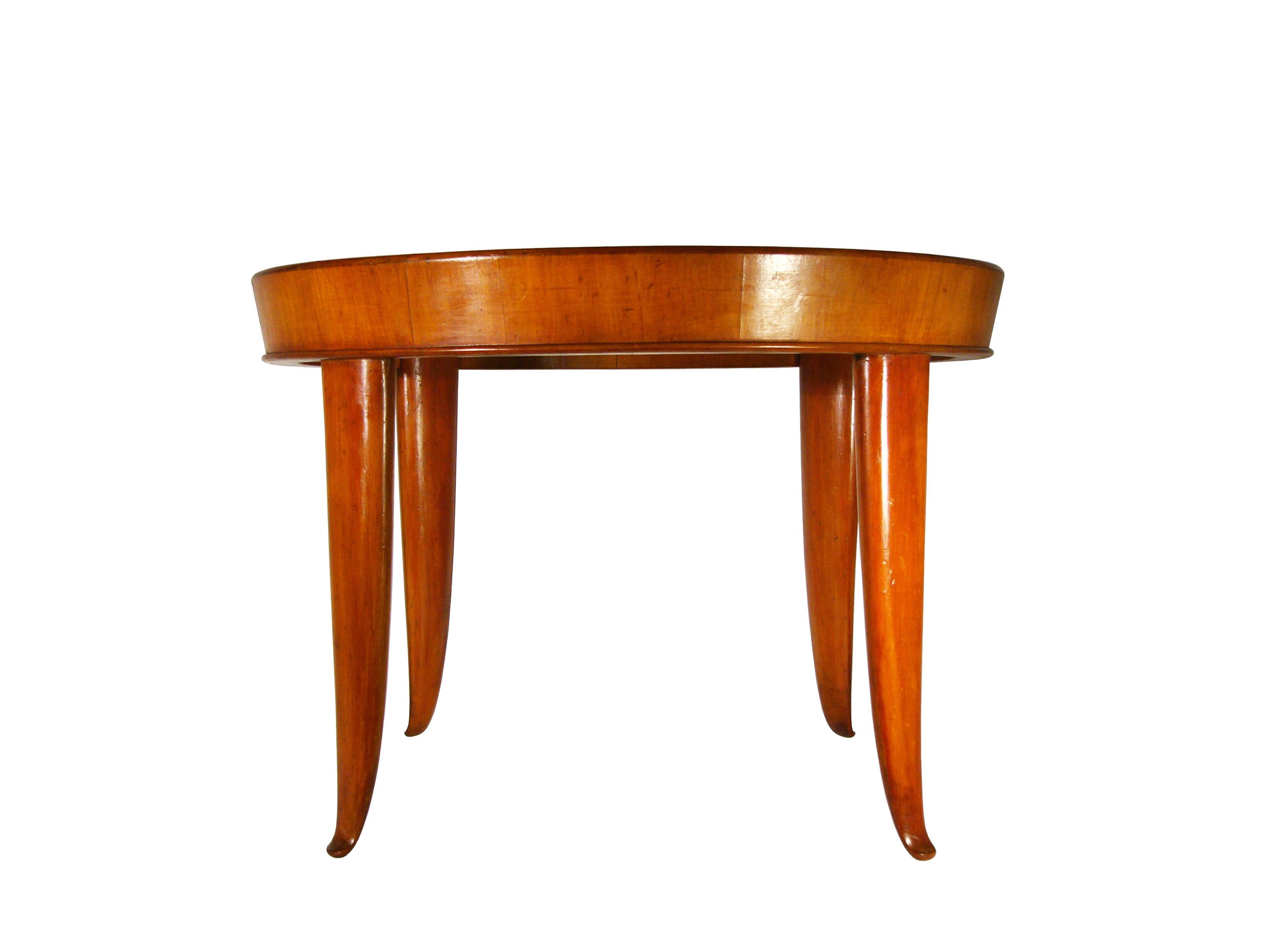 This elegant coffee table was produced in Italy in the 1940s and it is attributed to Guglielmo Ulrich, as it resembles other very models closely. It is made from a wooden structure with a round glass top. The table has been partially restored and
