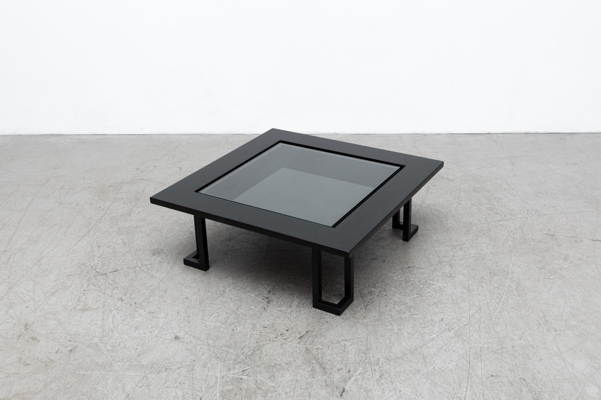 Italian black lacquered wood coffee table with inset glass and black painted steel legs. Inside display compartment under glass. In original condition with some wear to frame and light scratches on glass. Wear is consistent with age and use.