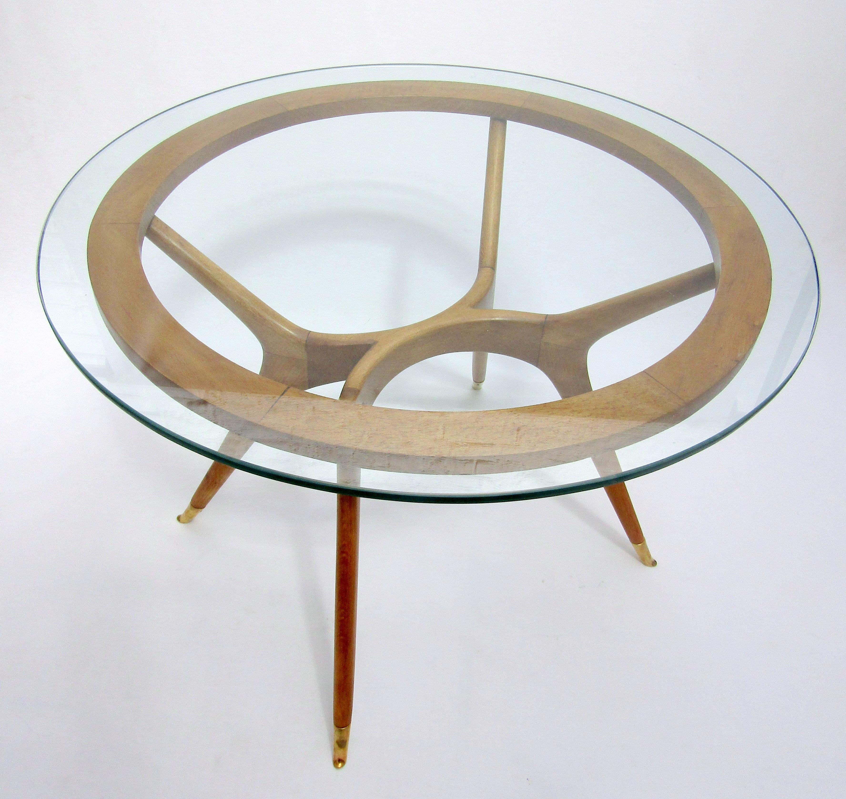 A circular wood and glass side table with
brass sabots in the style of Ico Parisi
Italian, circa 1950.

Measures: Height 19 ¼ in / 49 cm
Diameter 27 ¼ in / 69 cm.