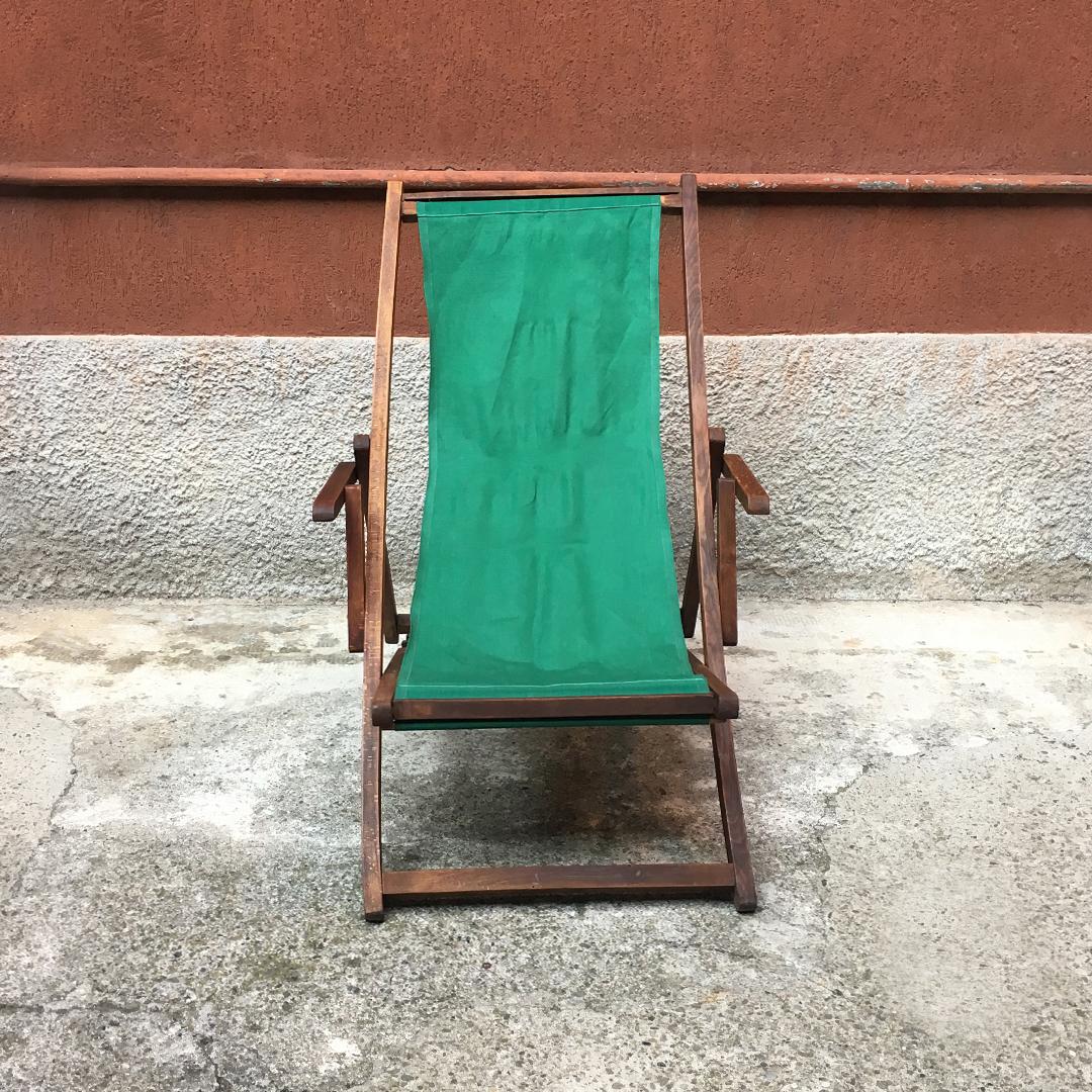 Italian wood and green fabric deckchair with armrests, 1960s
Deckchair with armrests and wooden structure with seat in green fabric, 1960s.
Variable sizes based on seat position
Very good condition.
Measures 94 x 100 x 56 H cm.
   