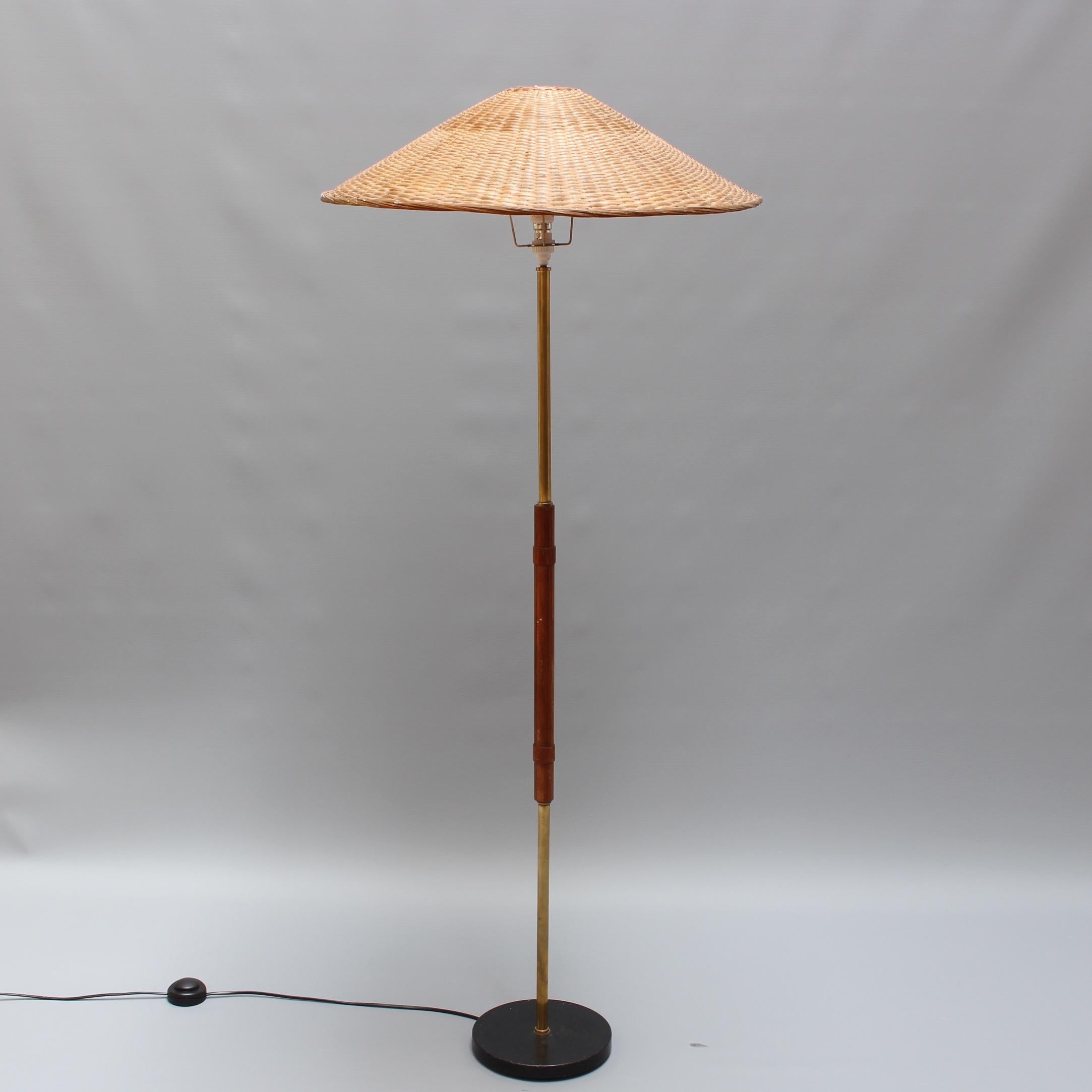 A stylish vintage Italian wood and metal floor lamp, circa 1960s. This lamp somehow reminds one of the warmth of the Italian coast in summer whilst watching the sunset from the terrace and sipping Campari-orange on the rocks. The mid-section is