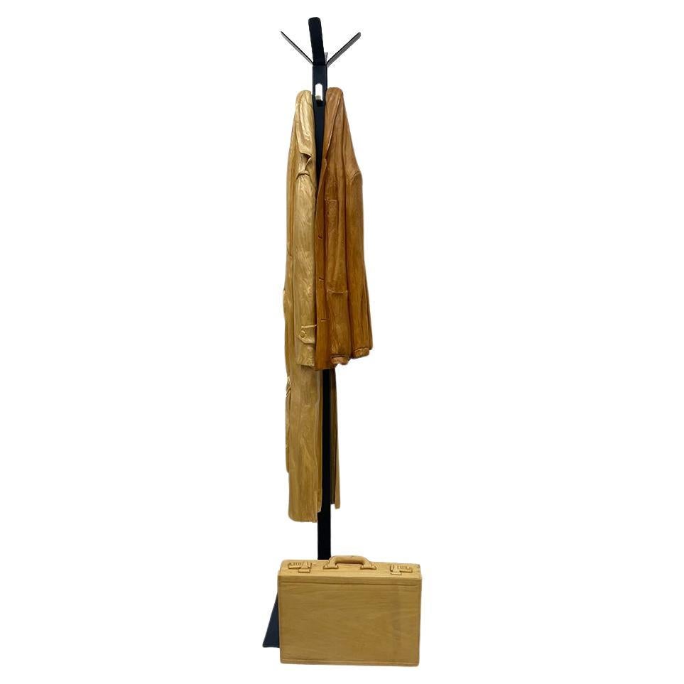 Italian wood-carved sculptures with raincoat and jacket on metal coat rack