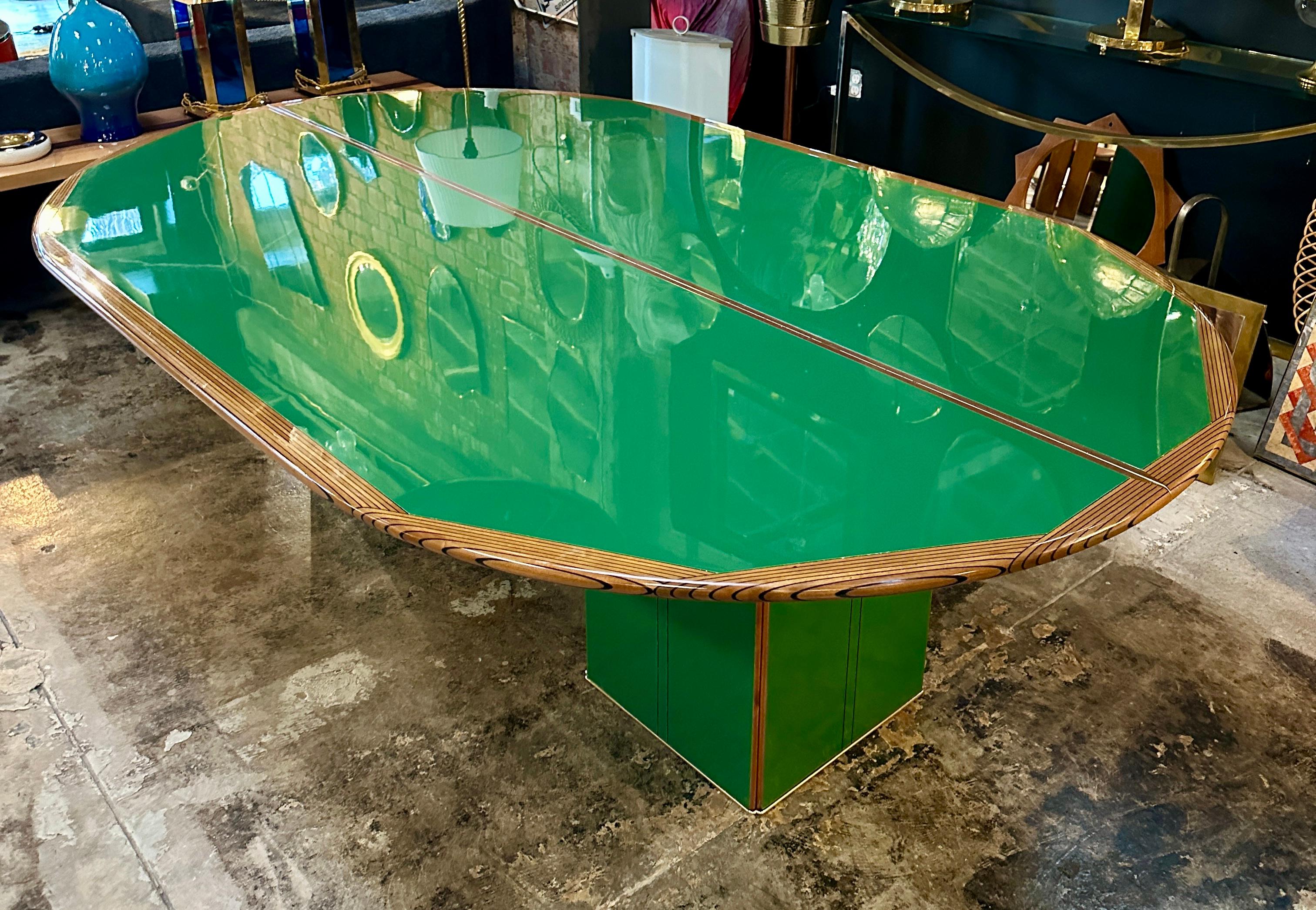 Dieser bemerkenswerte Esstisch der italienischen Designer Afra und Tobia Scarpa besticht durch seine grüne Holzplatte, die sofort die Aufmerksamkeit auf sich zieht. Eingerahmt von elegant geschwungenen Holzdetails, verbindet die Tischplatte moderne