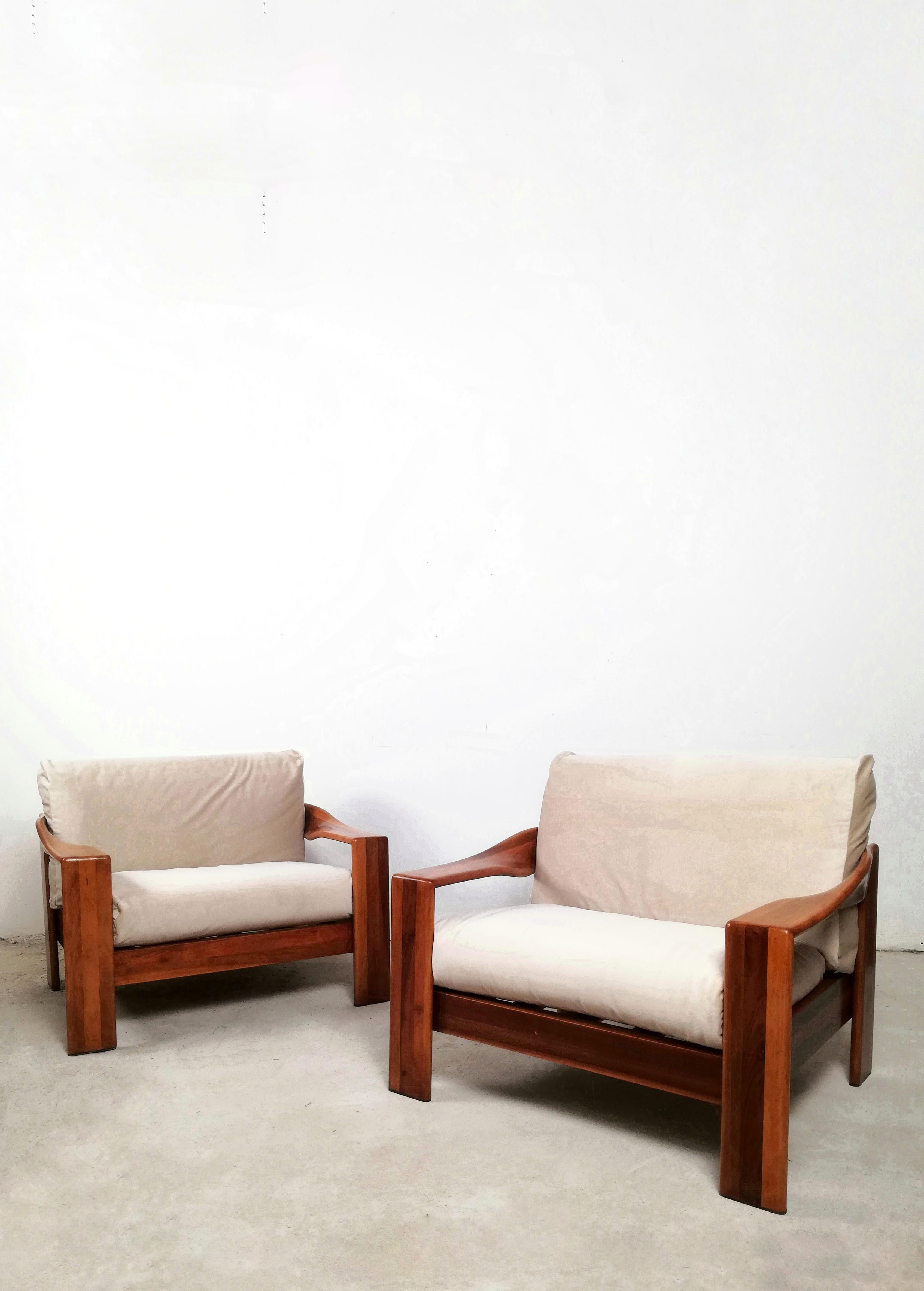 Pair of 1970s Italian-made armchairs made of solid walnut wood.
Both composed of a trio of wooden bands attached to each other that allow the creation of a twist on a material that seemingly seems massive and inflexible.
The armrests flexed like