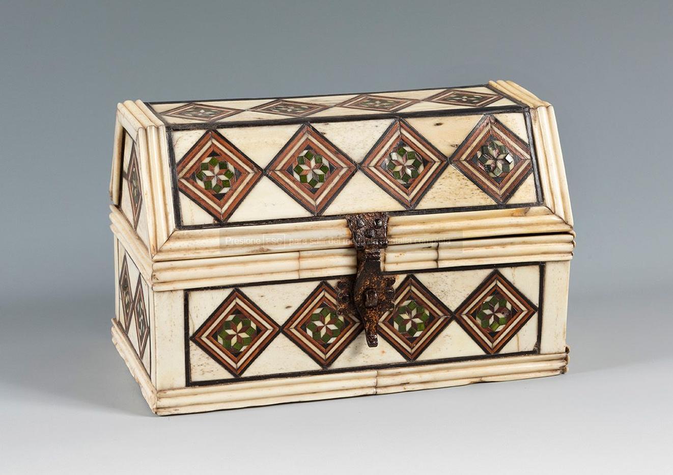 The chest is constructed from a wooden core, covered on the outside with a beautiful geometric ornamental marquetry design. It has a lock on the front. The decoration is organised in rhomboid-shaped strips of stained walnut and bone wood, using the