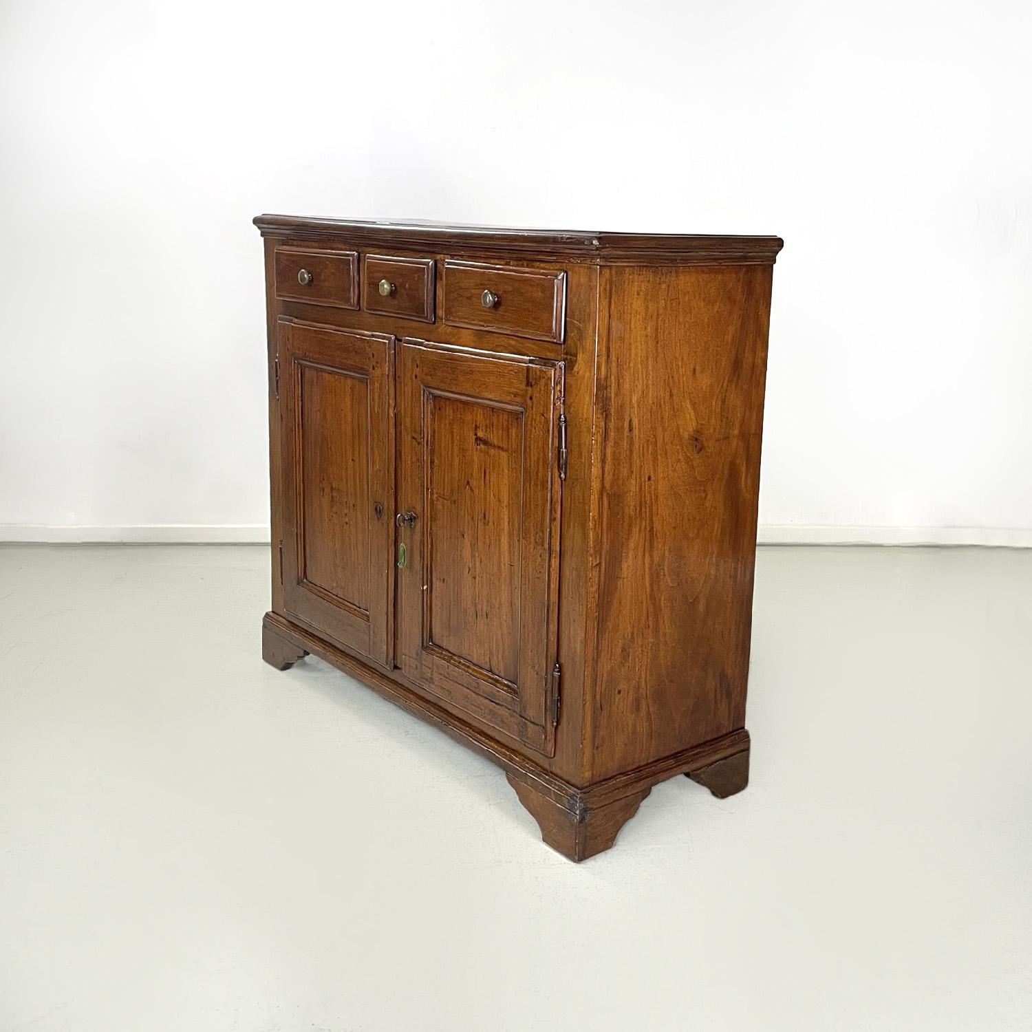 Italian wooden sideboard with three drawers and two doors, 1900s
Sideboard with rectangular base entirely in wood. It has a top with shaped perimeter sides, underneath there are three drawers, the smaller central one with round brass knobs. In the